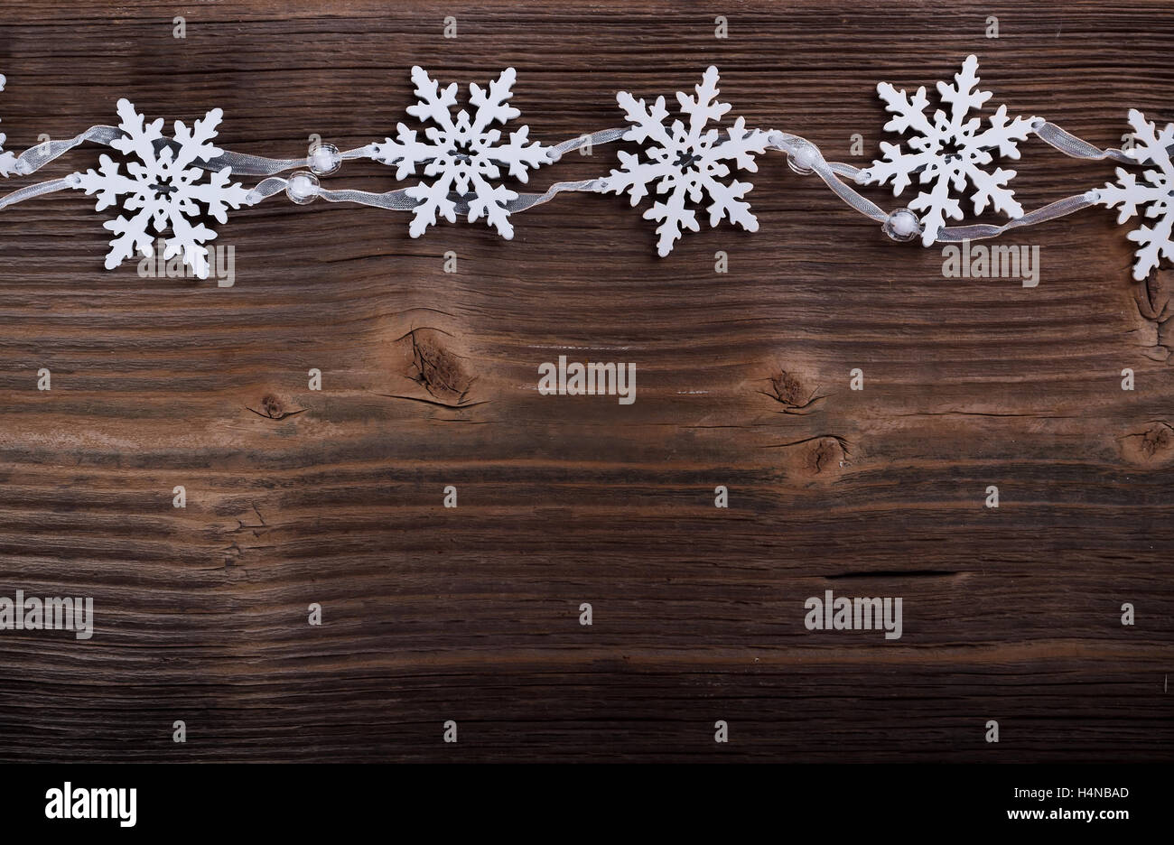 Fiocchi di neve artificiale sul vecchio sfondo di legno Foto Stock