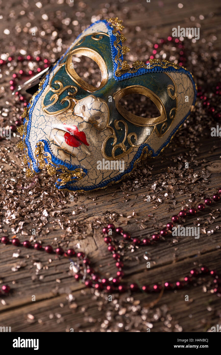 Maschera di carnevale con perle di rosso su sfondo di legno Foto Stock