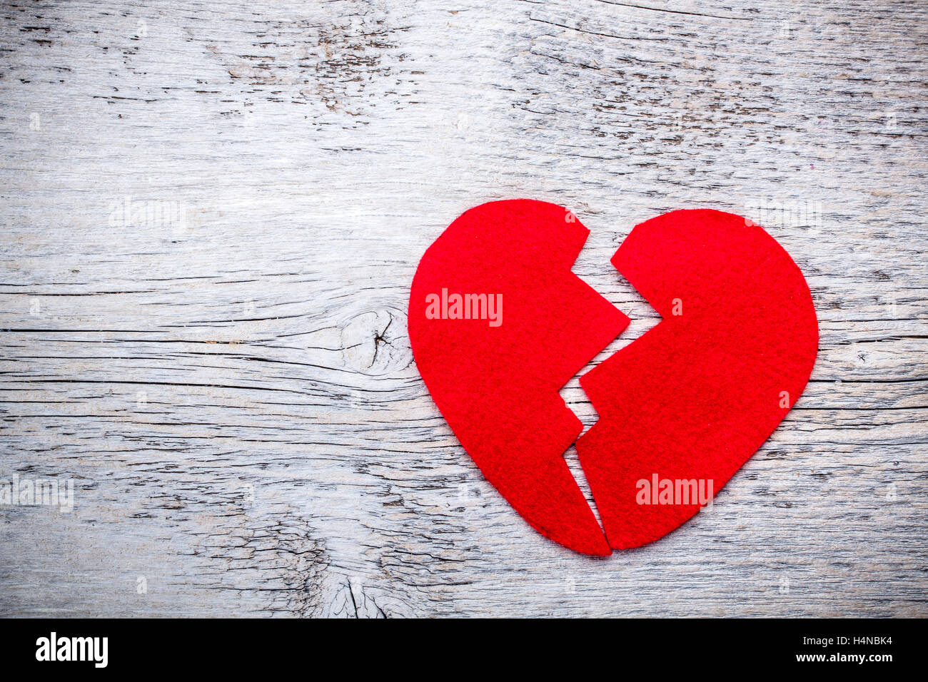 Feltro rosso cuore spezzato in due metà su un sfondo rosa Foto stock - Alamy