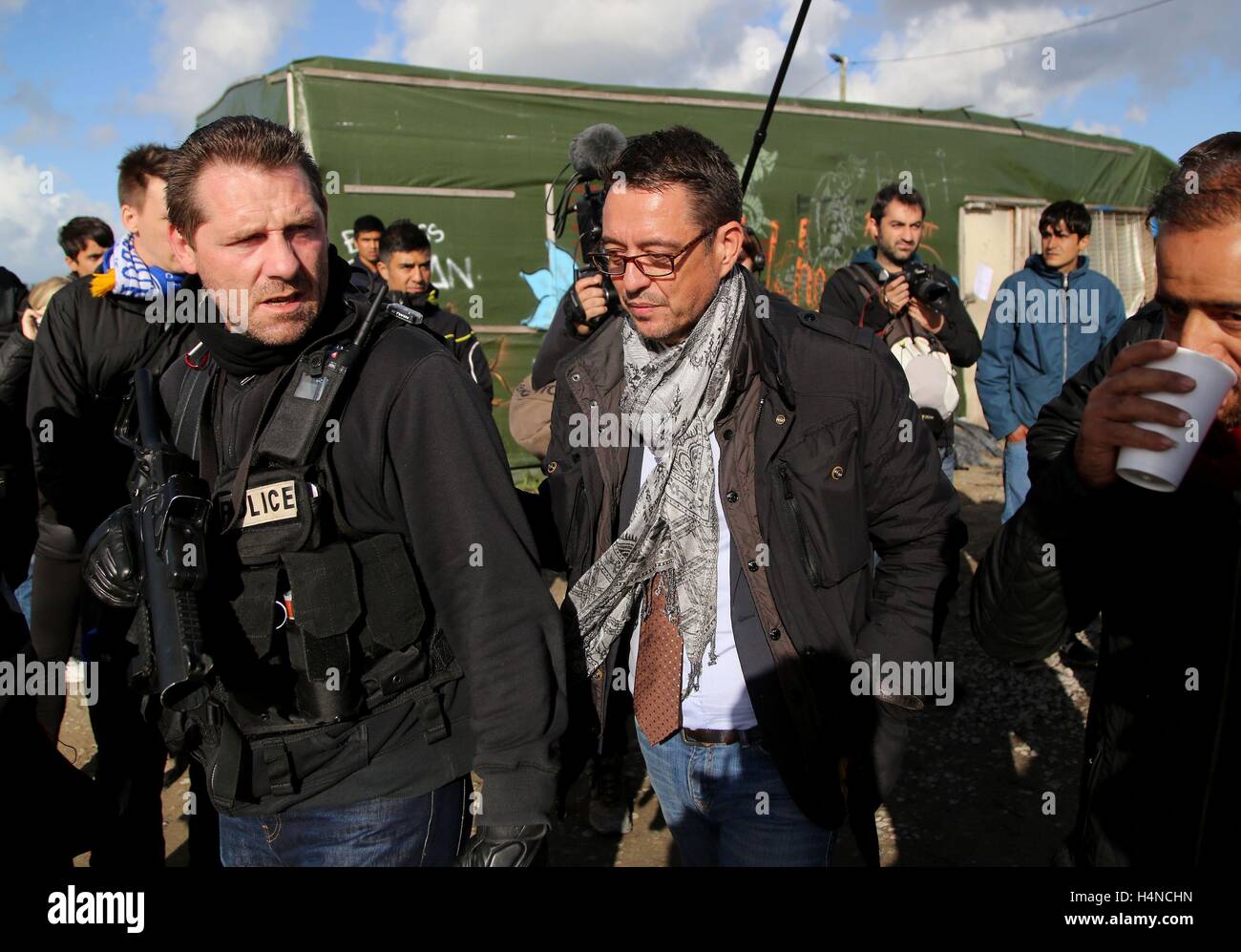 Calais signor commissario di polizia Patrick Visser-Bourdon (centro) visite la giungla campo di migranti a Calais, Francia, come le comunicazioni di sfratto sono serviti per negozi sul sito come i piani sono fatti per cancellare tutto il camp. Stampa foto di associazione. Picture Data: lunedì 17 ottobre, 2016. Bandi di gara è stato pubblicato in negozi in Calais camp noto come 'giungla' avvertenza devono essere evacuato entro due giorni prima della demolizione di edifici di fortuna nella baraccopoli. Il porto della città commissario di polizia Patrick Visser-Bourdon ha visitato la baraccopoli in cui notifica legale dell'ordine di lasciare i negozi è stata po Foto Stock