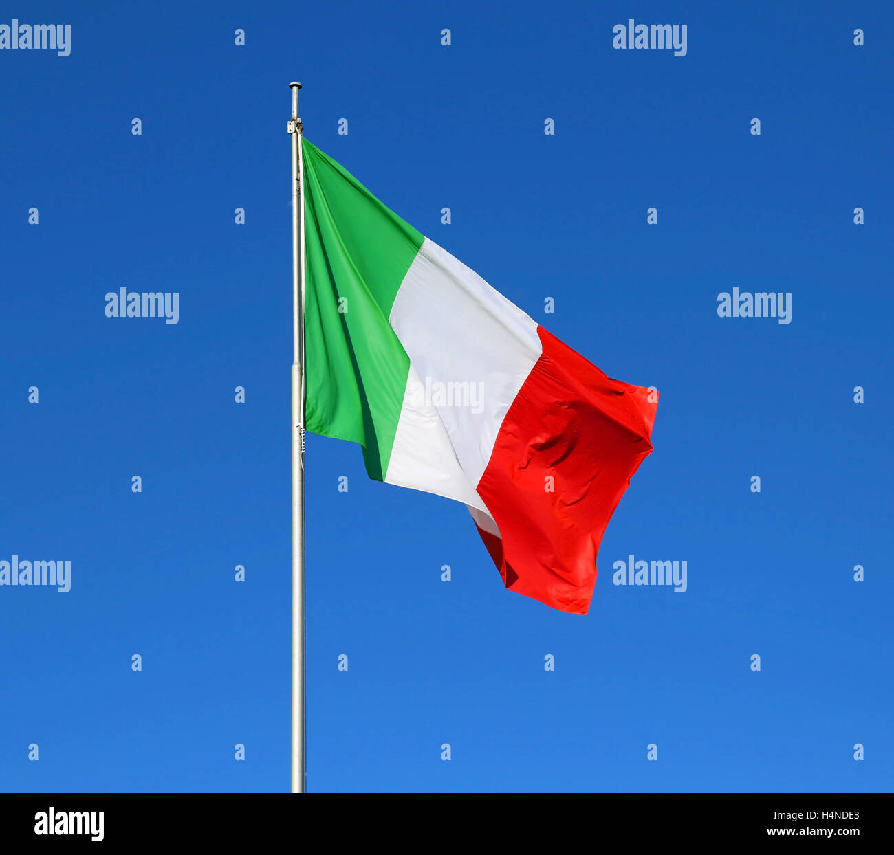 Grande bandiera italiana sventolare nel cielo blu Foto Stock