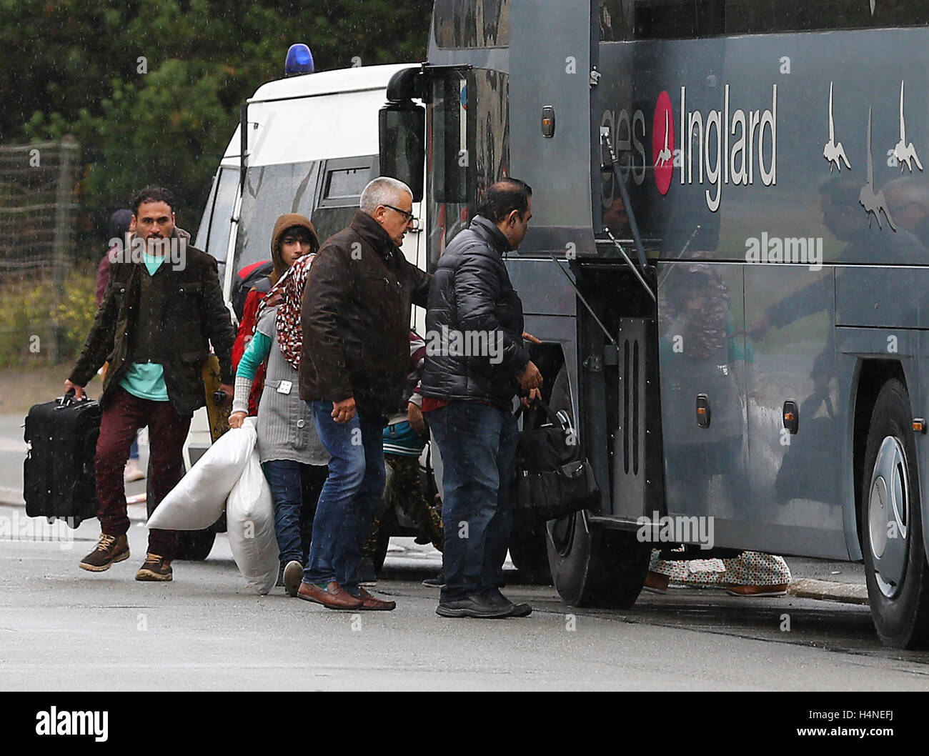 Una famiglia di schede madri con un pullman per lasciare la giungla campo di migranti a Calais, Francia, per iniziare una nuova vita nel sud della Francia come i piani sono fatti per demolire il camp nelle prossime settimane. Foto Stock