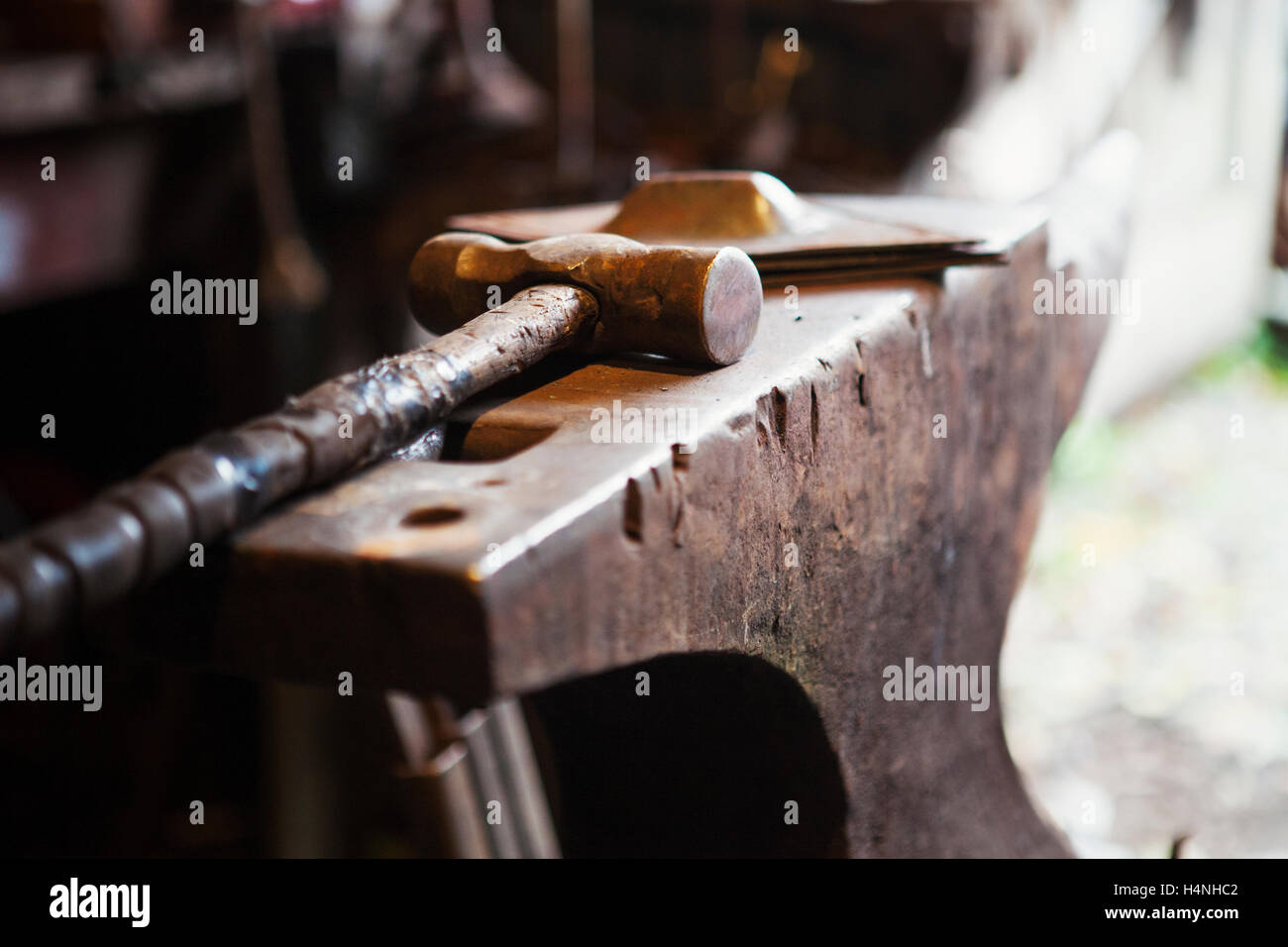 Close up di un martello metallico giacente su incudine in un fabbro della bottega. Foto Stock