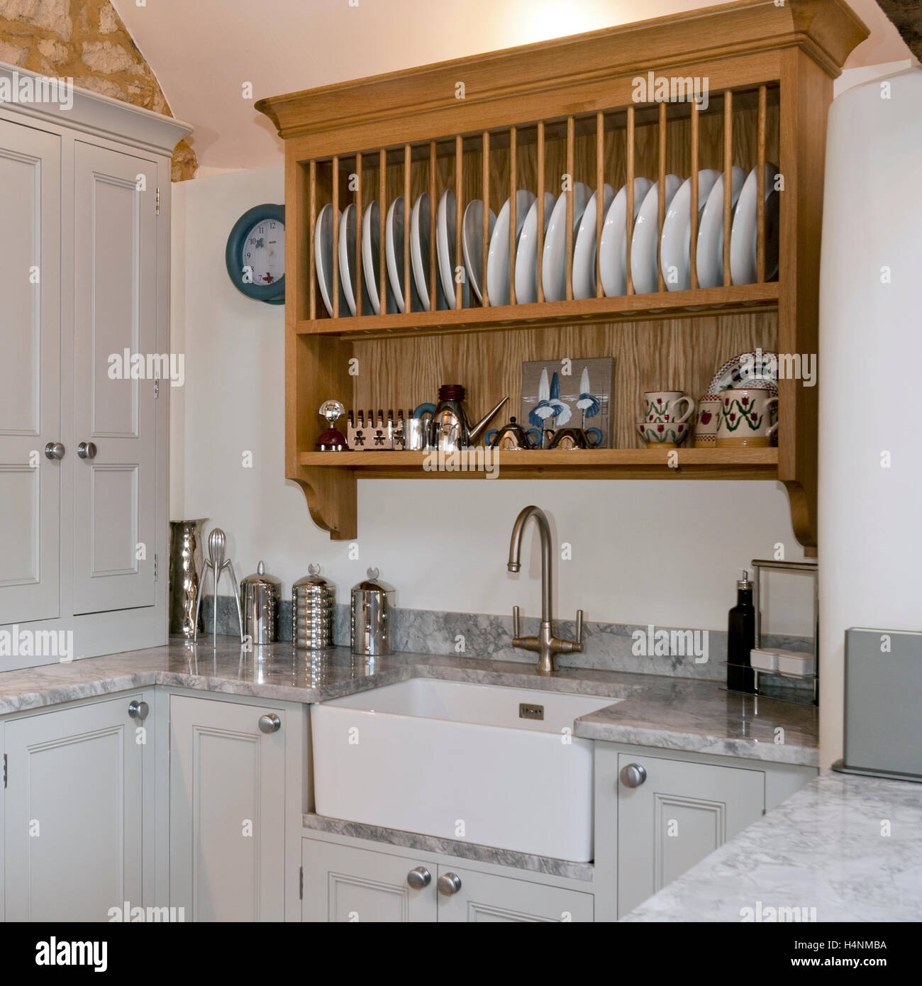Tradizionale piatto di legno il ripiano di un rack sopra vernice contemporaneo finito di mobili da cucina e un lavandino in porcellana Foto Stock