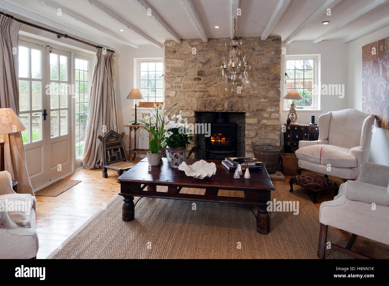 Un contemporaneo arredato cottage salotto con un caminetto e una caratteristica di stufa a legna Foto Stock