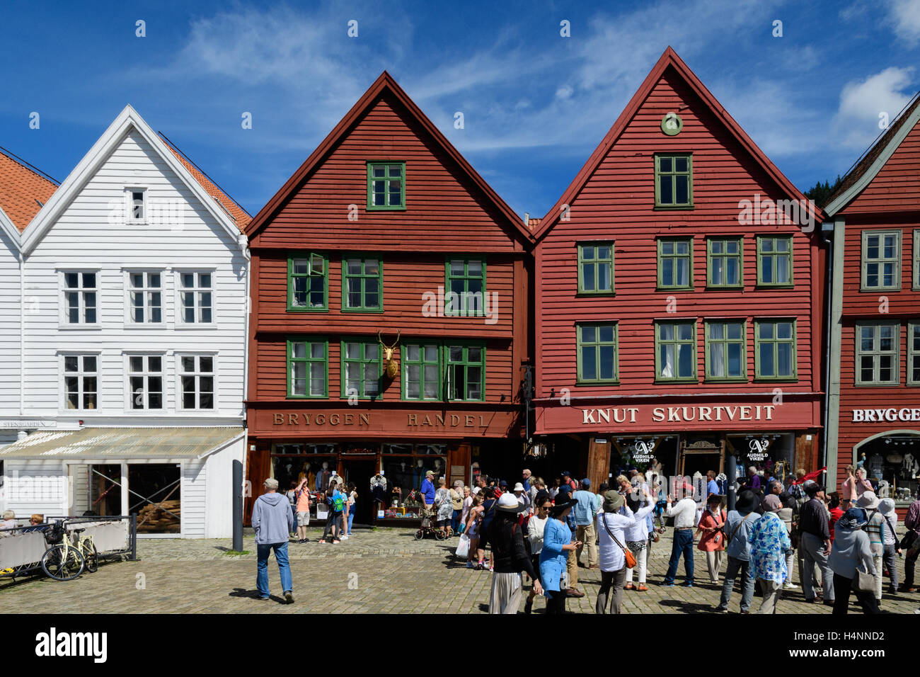 Gruppo di turisti asiatici presso i magazzini di legno e negozi, Bryggen, Bergen, Norvegia Foto Stock