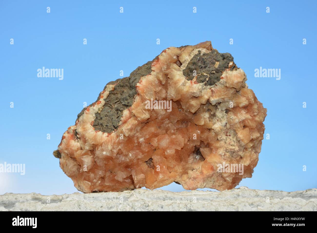 Orange minerali pietra sul muro bianco contro un cielo blu Foto Stock