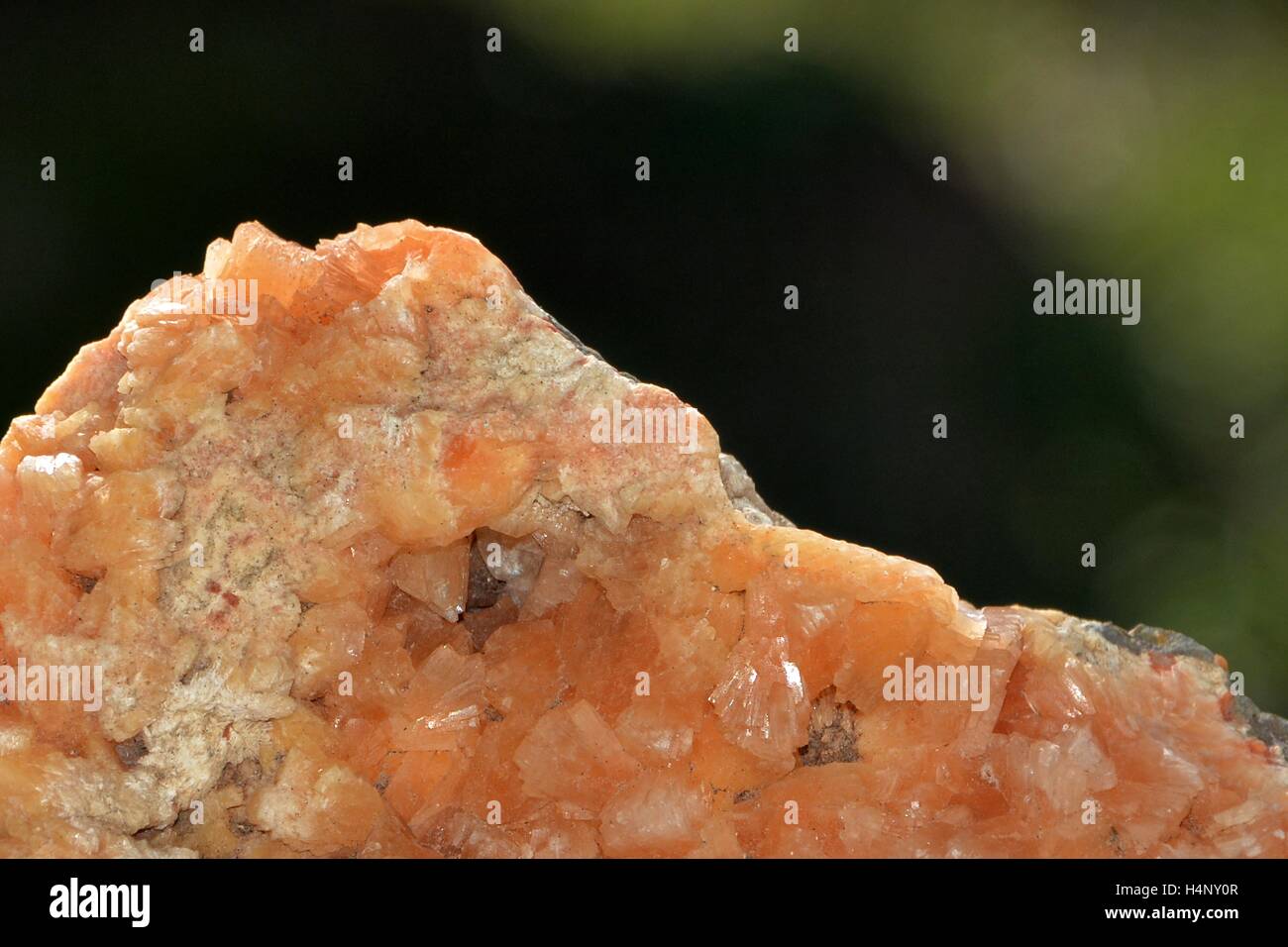 Orange minerali di pietra di quarzo in dettaglio con sfondo verde Foto Stock