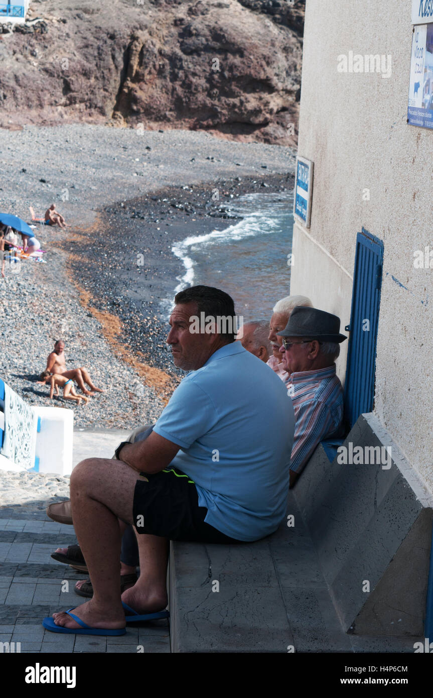 Fuerteventura Isole Canarie, Nord Africa, Spagna: locale anziani seduti all'ombra al vecchio porto di El Cotillo Foto Stock