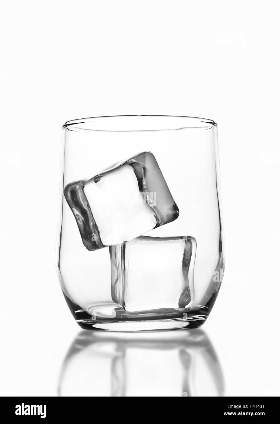 Vuoto in vetro di whiskey con cubetti di ghiaccio isolato su sfondo bianco Foto Stock