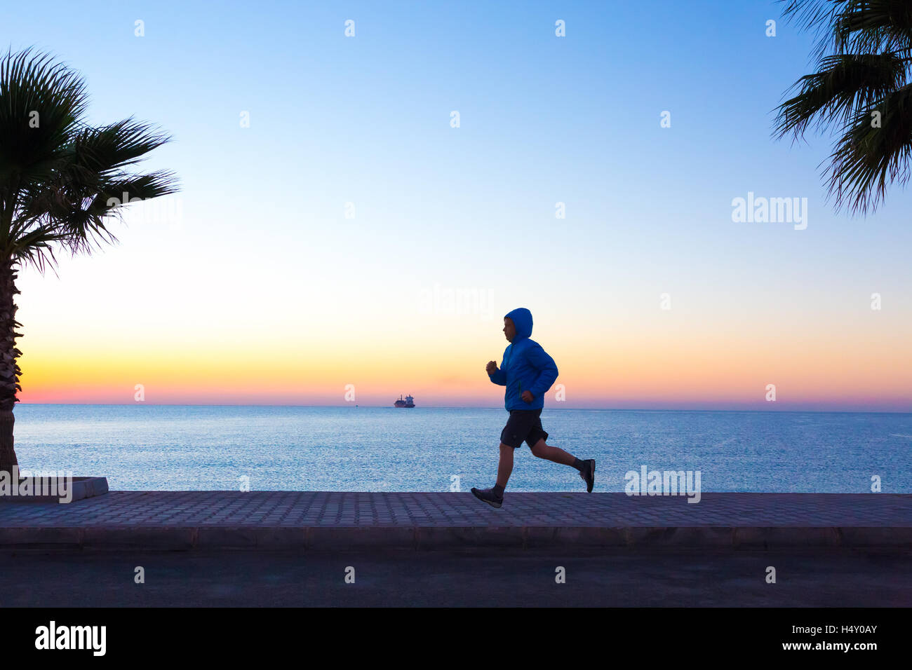 Uomo sportivo di jogging sul lungomare rendendo Fitness di mattina Foto Stock