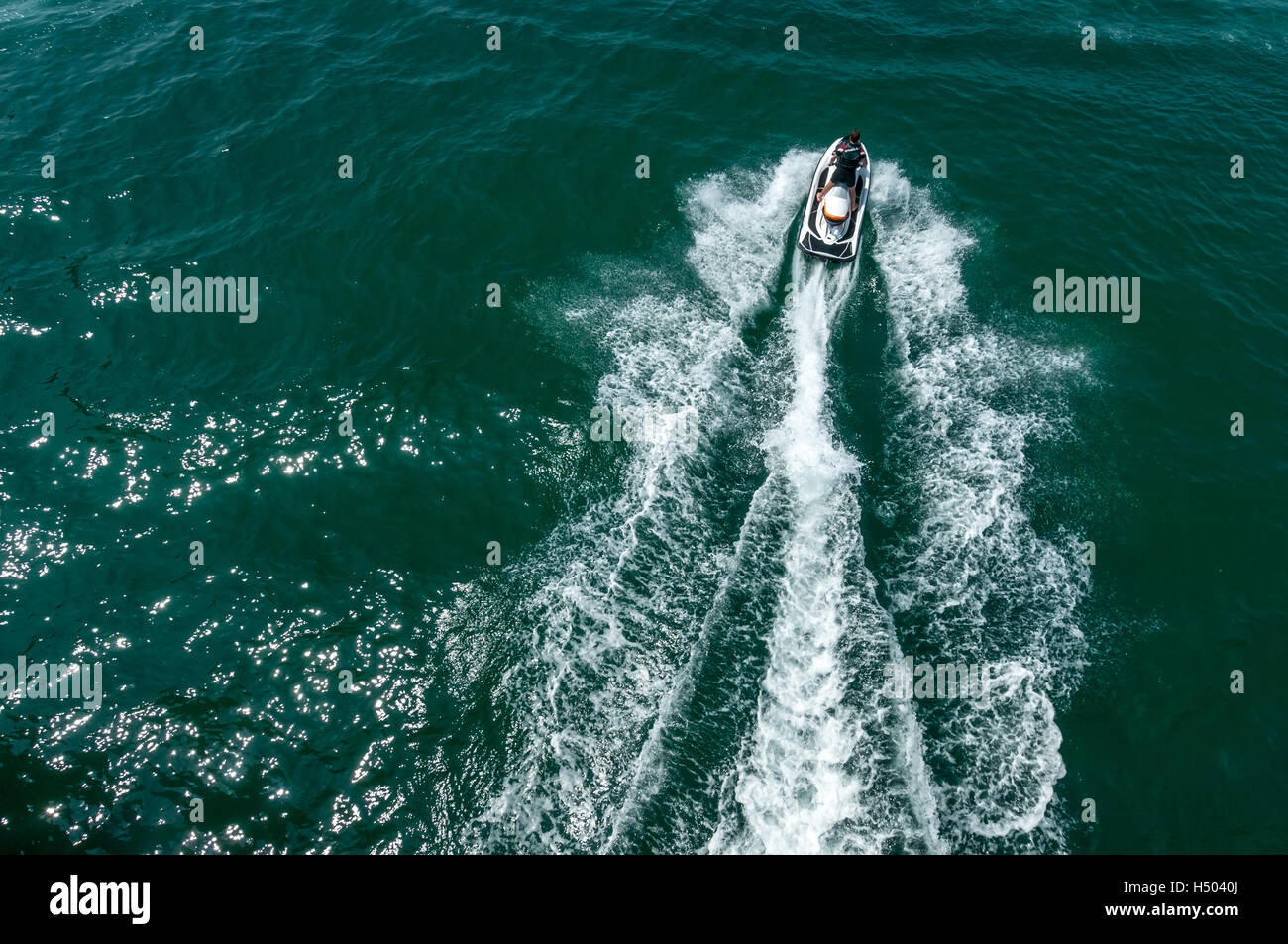 Un uomo su un jet ski tuona sopra l'acqua sulla costa sud dell'Inghilterra Foto Stock