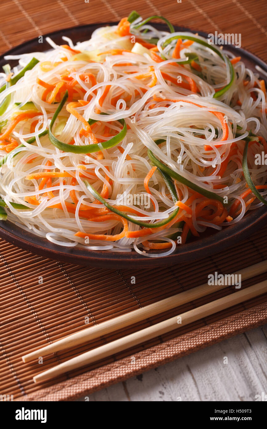 Tagliatelle cinesi con il cetriolo e la carota su una piastra di close-up. In verticale Foto Stock