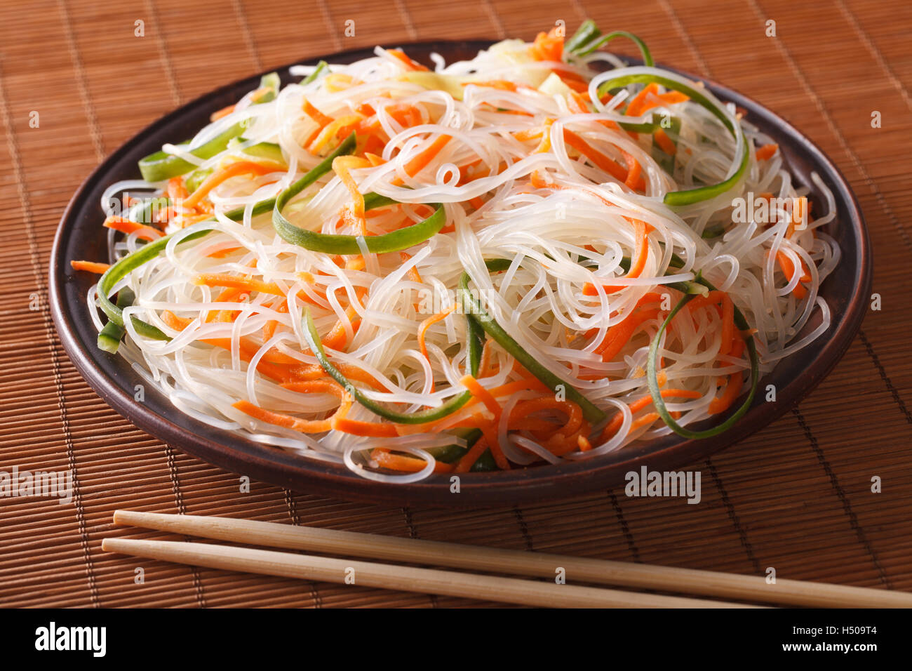 Tagliatelle cinesi con il cetriolo e la carota su una piastra di close-up orizzontale. Foto Stock