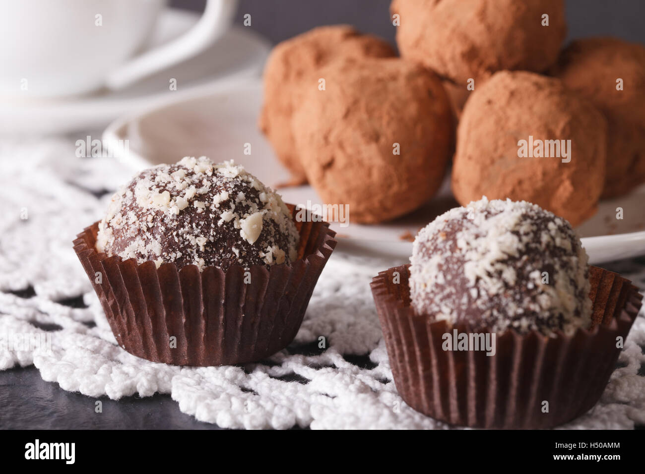 Francese tartufo al cioccolato dolci closeup su una tovaglia di pizzo. Posizione orizzontale Foto Stock