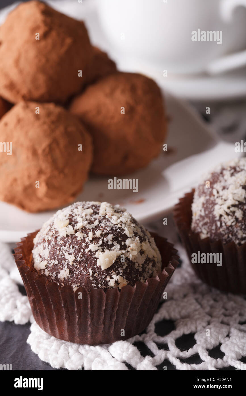 Delizioso tartufo al cioccolato caramelle macro su una tovaglia di pizzo verticale. Foto Stock