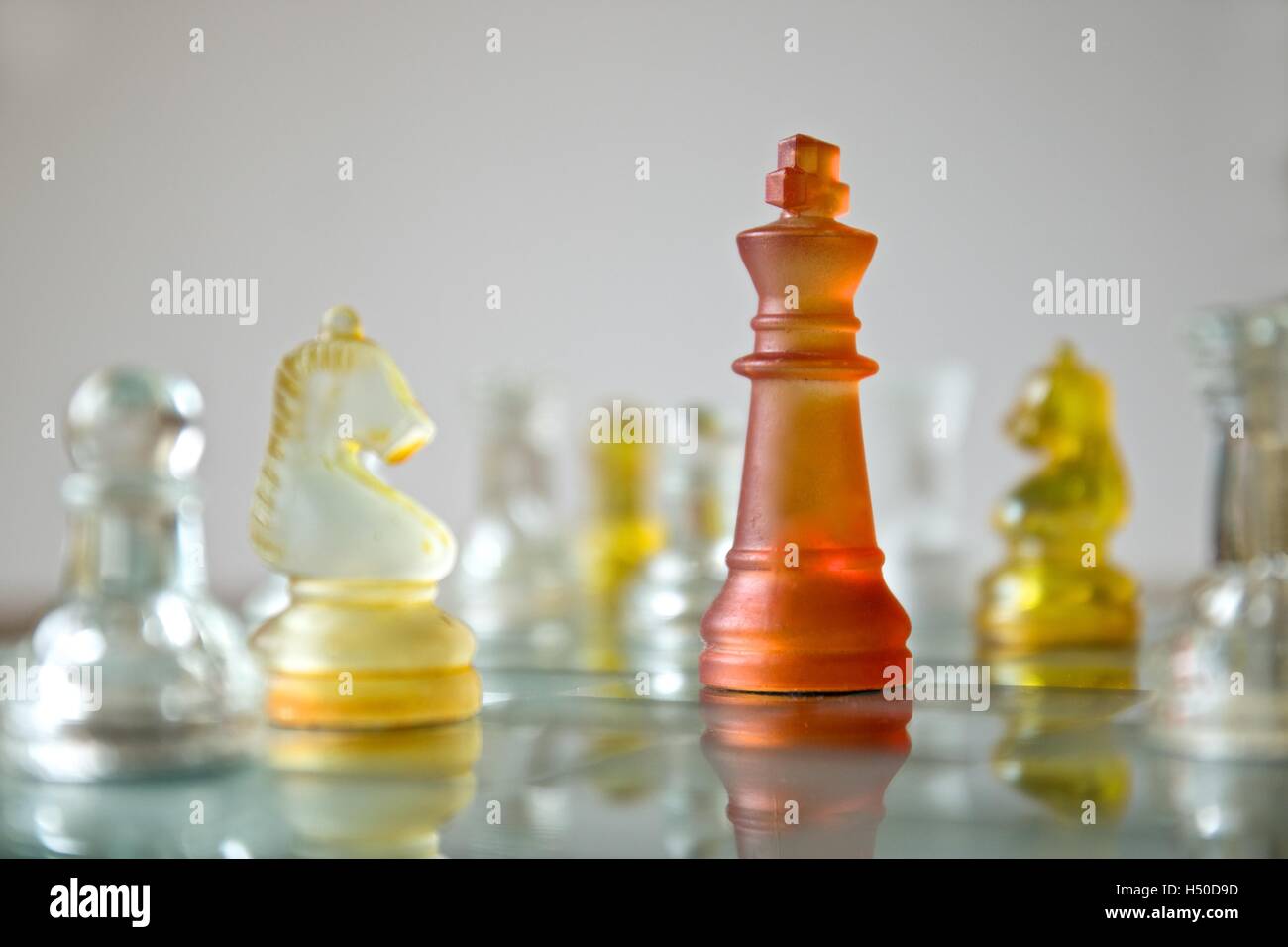 Vetro cristallo colore pezzo degli scacchi su una scacchiera Foto Stock