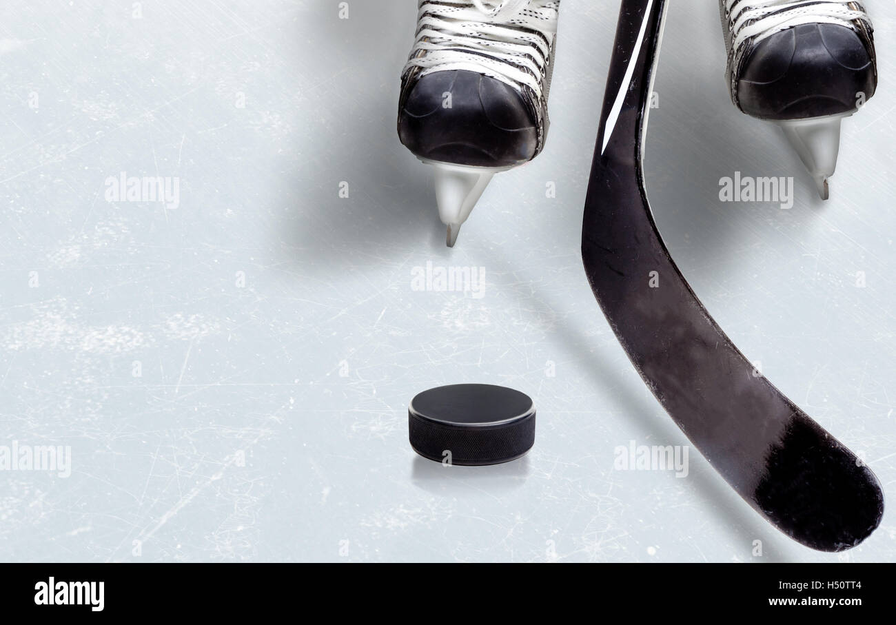 Hockey su ghiaccio che mostra stick su puck con parte del giocatore di pattini sul ghiaccio e copia dello spazio. Foto Stock