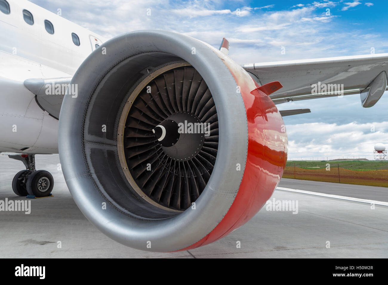 Un aereo con focus sul suo motore rosso sulla pista di un aeroporto. Foto Stock