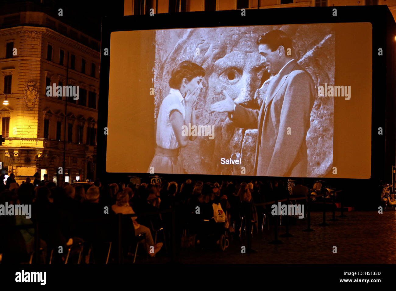 Roma. Xviii oct, 2016. La gente guarda il filmato Roma Holiday starring Gregory Peck e Audrey Hepburn a Piazza di Spagna il 18 ottobre 2016 a Roma, Italia. Il ben noto film Roma Holiday starring Gregory Peck e Audrey Hepburn è stato proiettato il martedì a Piazza di Spagna a Roma per celebrare il centenario della nascita di Gregory Peck. © Jin Yu/Xinhua/Alamy Live News Foto Stock