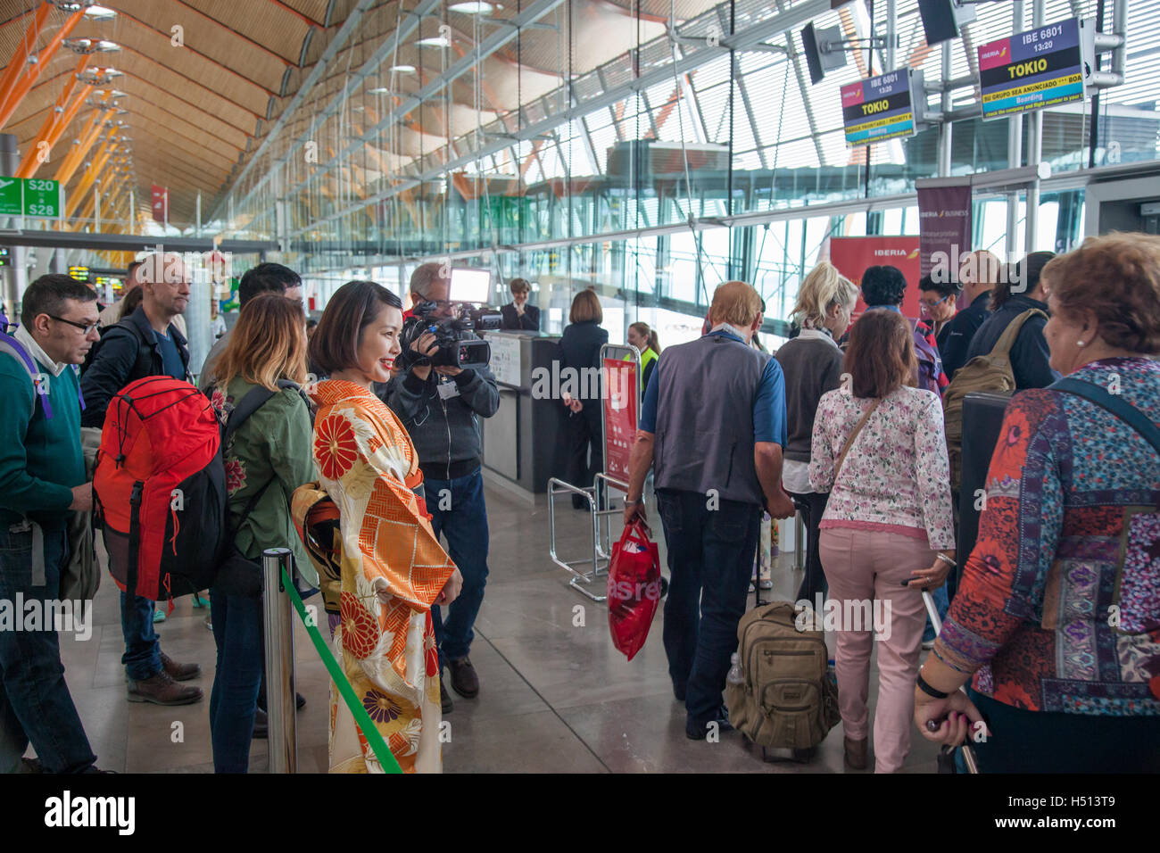 Passeggeri e media di salire a bordo del primo diretta inaugurale Iberia volo fra Spagna e Giappone (IB6801 Madrid Barajas a Tokyo Narita il 18 ottobre 2016) mentre viene accolto da ragazza giapponese vestita in tradizionali abiti kimono Foto Stock