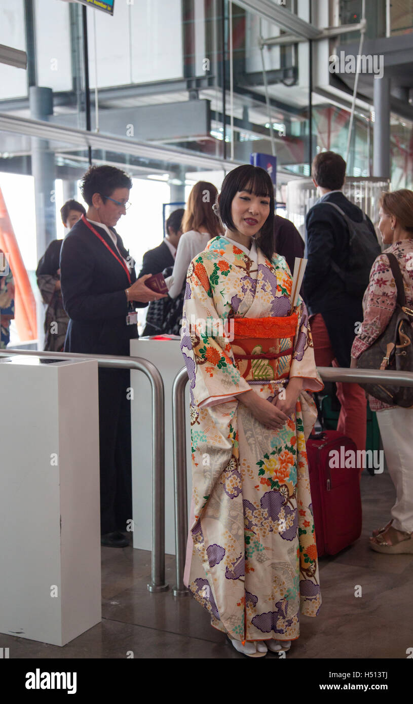 Ragazza giapponese vestita in kimono tradizionale accogliente passeggeri e media di salire a bordo del primo diretta inaugurale Iberia volo fra Spagna e Giappone (IB6801 Madrid Barajas a Tokyo Narita il 18 ottobre 2016) Foto Stock