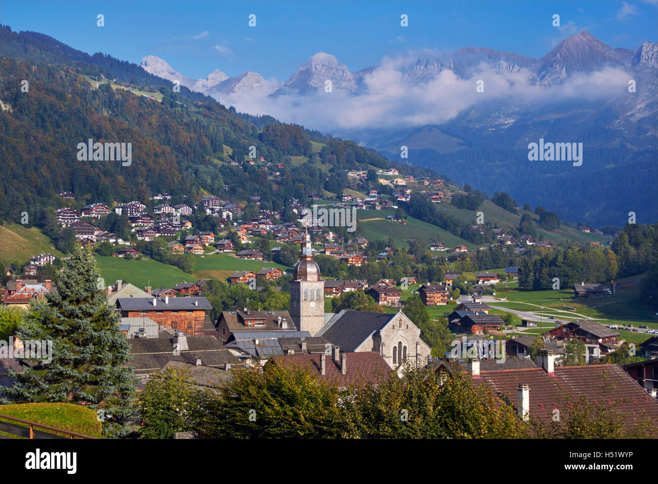 Vista sulla città di Le Grand Bornand con la Chaine des Aravis in distanza. Alta Savoia, Francia. Foto Stock