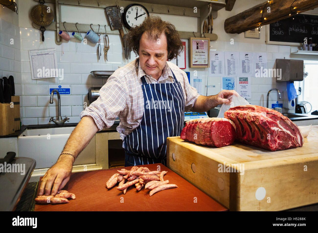 Butcher preparare un grande pezzo di carne di manzo in un butcherer's shop. Foto Stock
