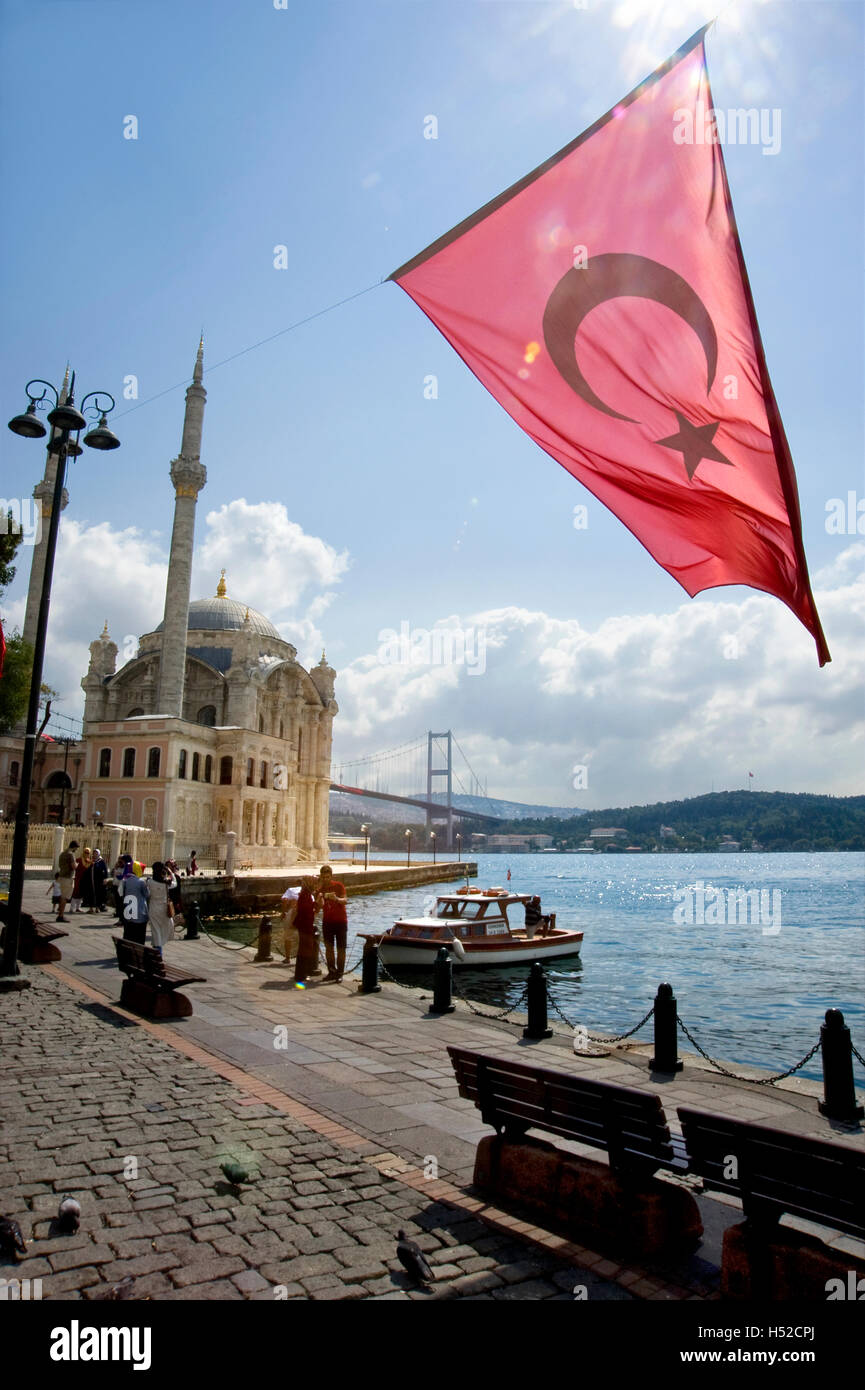 Bandiera turca e Moschea Ortakoy con ponte sul Bosforo mare in background in Istanbul, Turchia Foto Stock