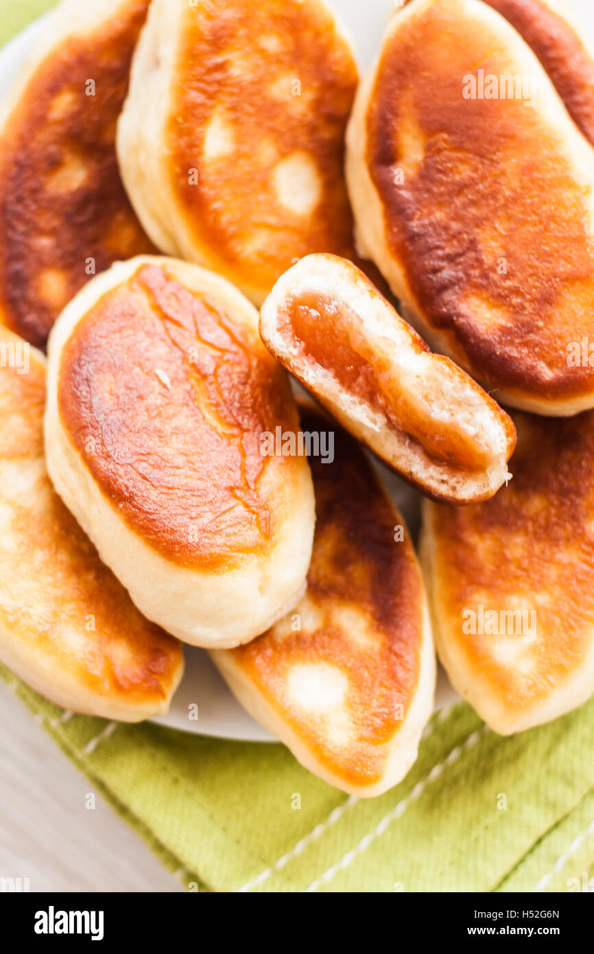 Dolci fritti con marmellata su un tovagliolo verde. Foto Stock