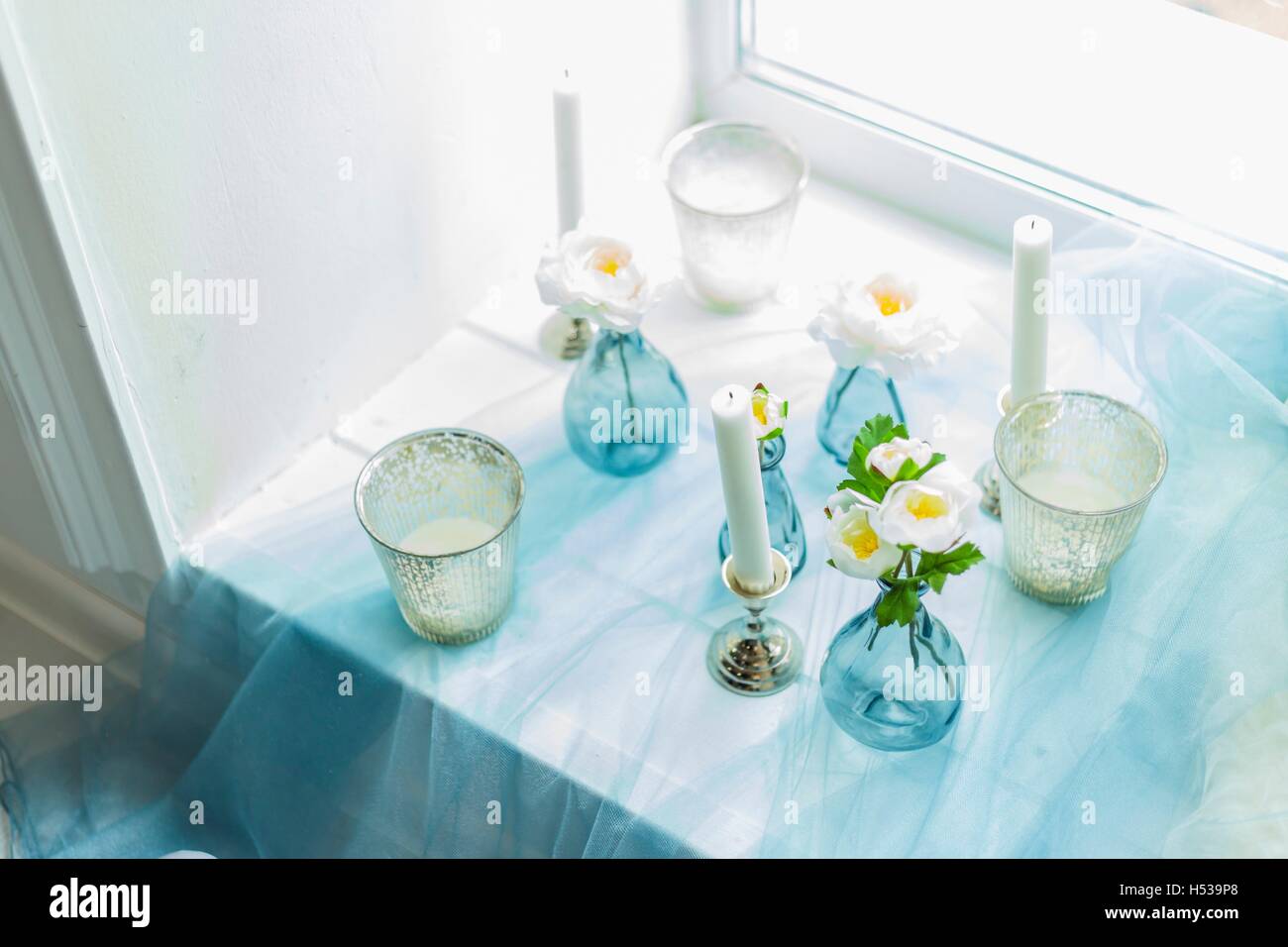 Il decor di photostudio - candele bianche, tessile blu Foto Stock