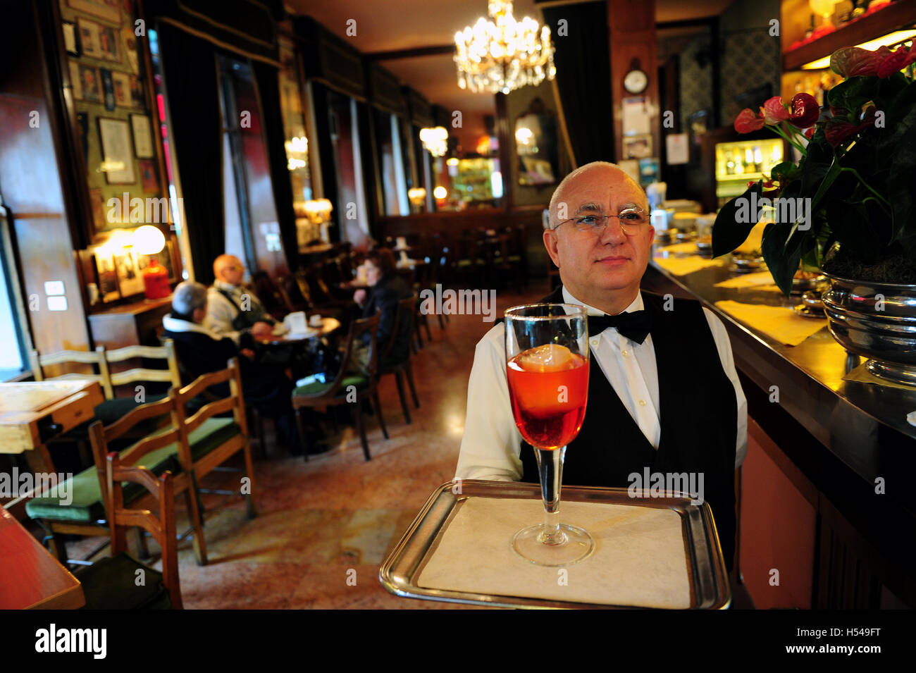 Un cameriere al bar Basso è servire il caffè marchio Negroni cocktail in vetro da 1 litro Foto Stock