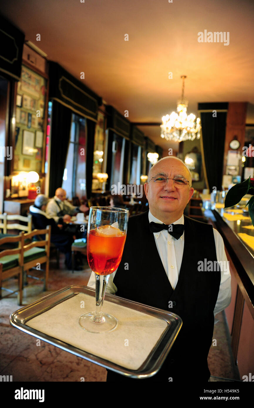 Un cameriere al bar Basso è servire il caffè marchio Negroni cocktail in vetro da 1 litro Foto Stock