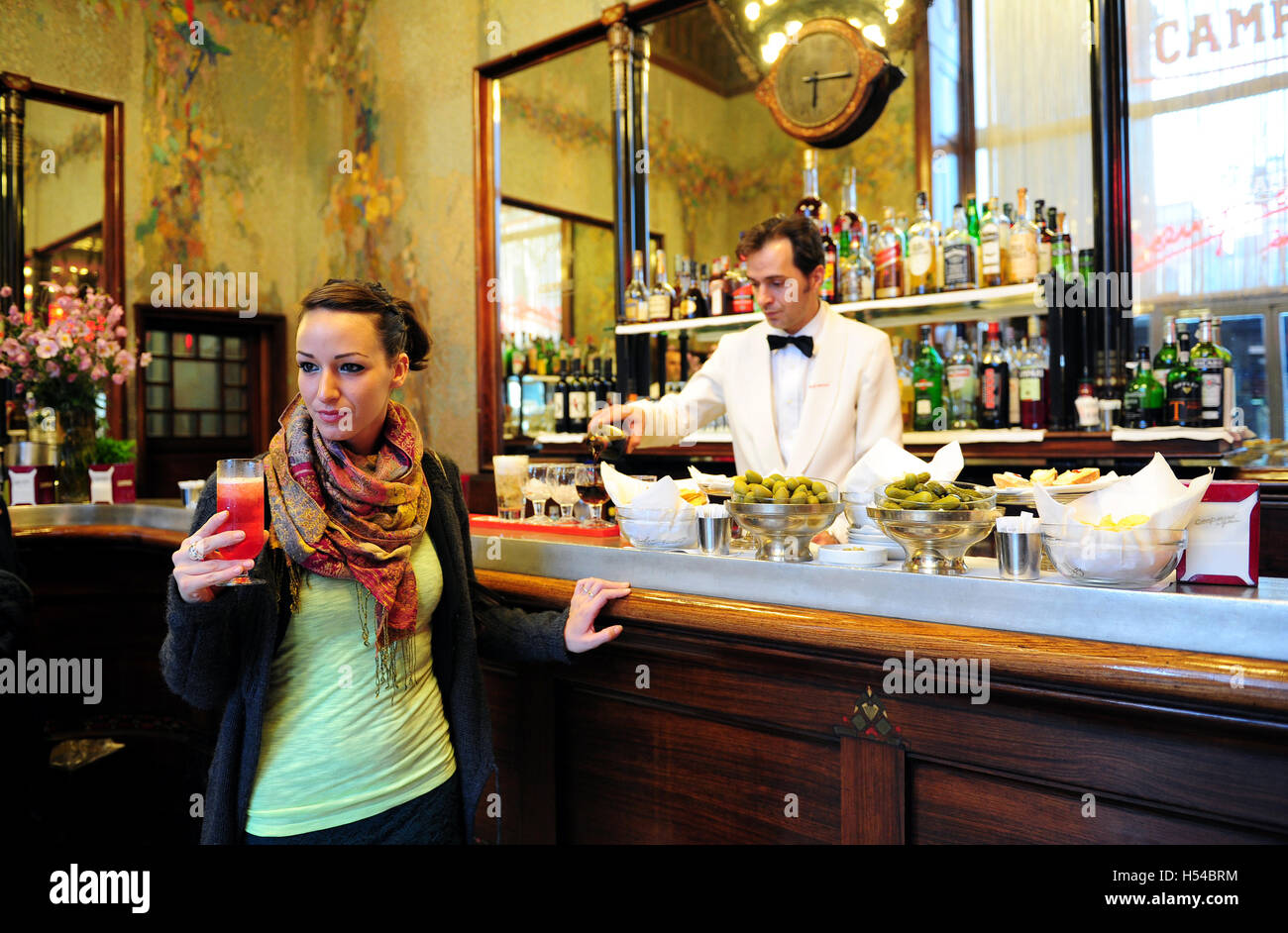 Una giovane donna è sorseggiando un Campari cocktail all'interno del Camparino cafe, in Galleria Vittorio Emanuele II a Milano, Italia Foto Stock