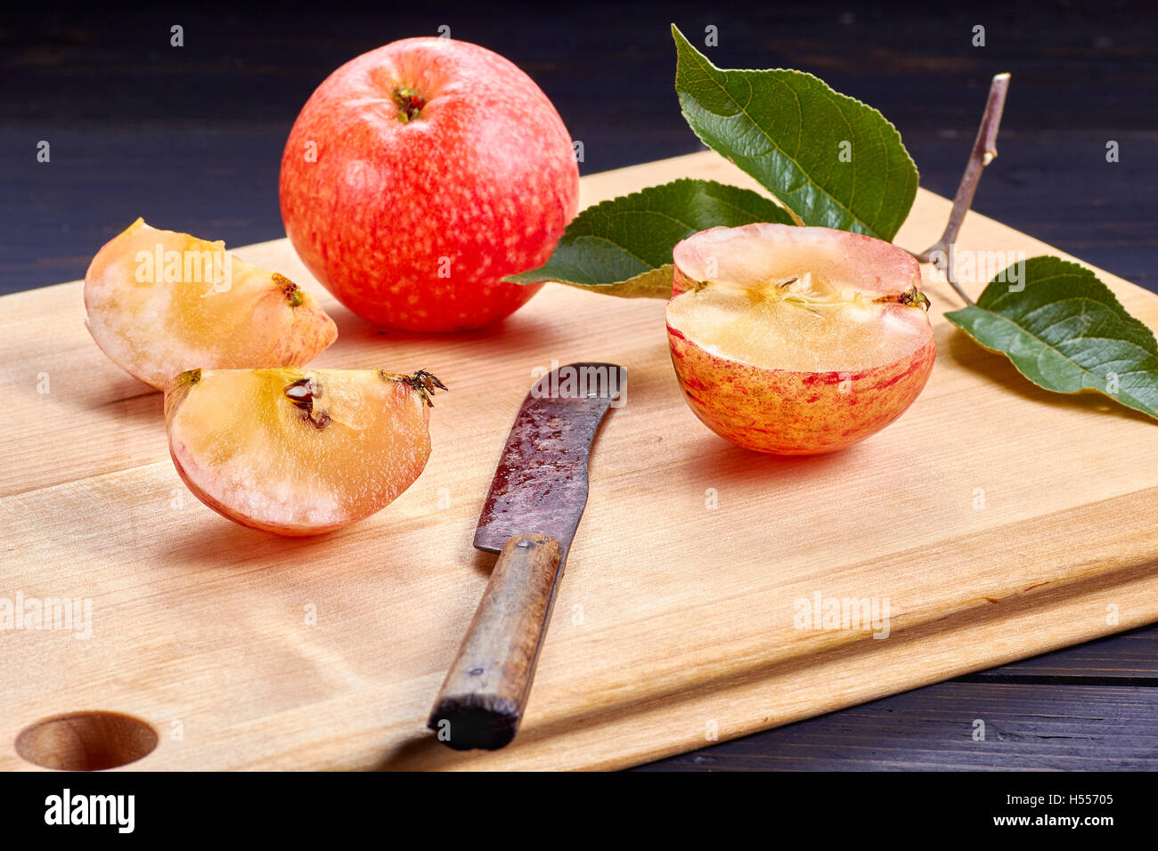 Molto mature e succosa mela con sezioni sul tagliere di legno Foto Stock