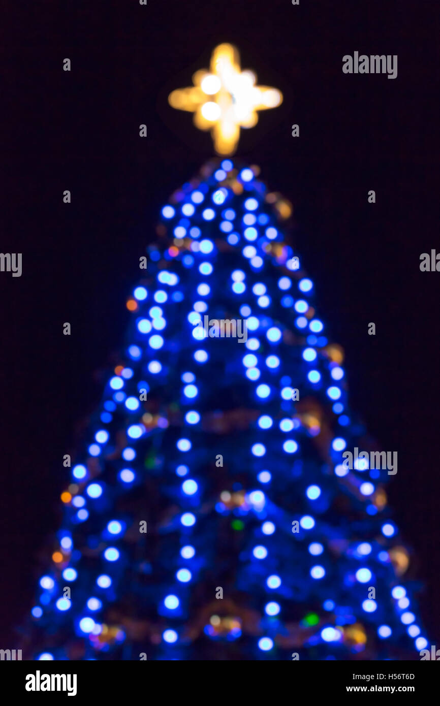 Sfocata illuminato blu albero di natale su sfondo nero Foto Stock