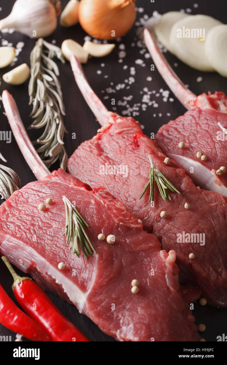 Raw bistecche di manzo con rosmarino su una tavola di ardesia closeup verticale. Foto Stock