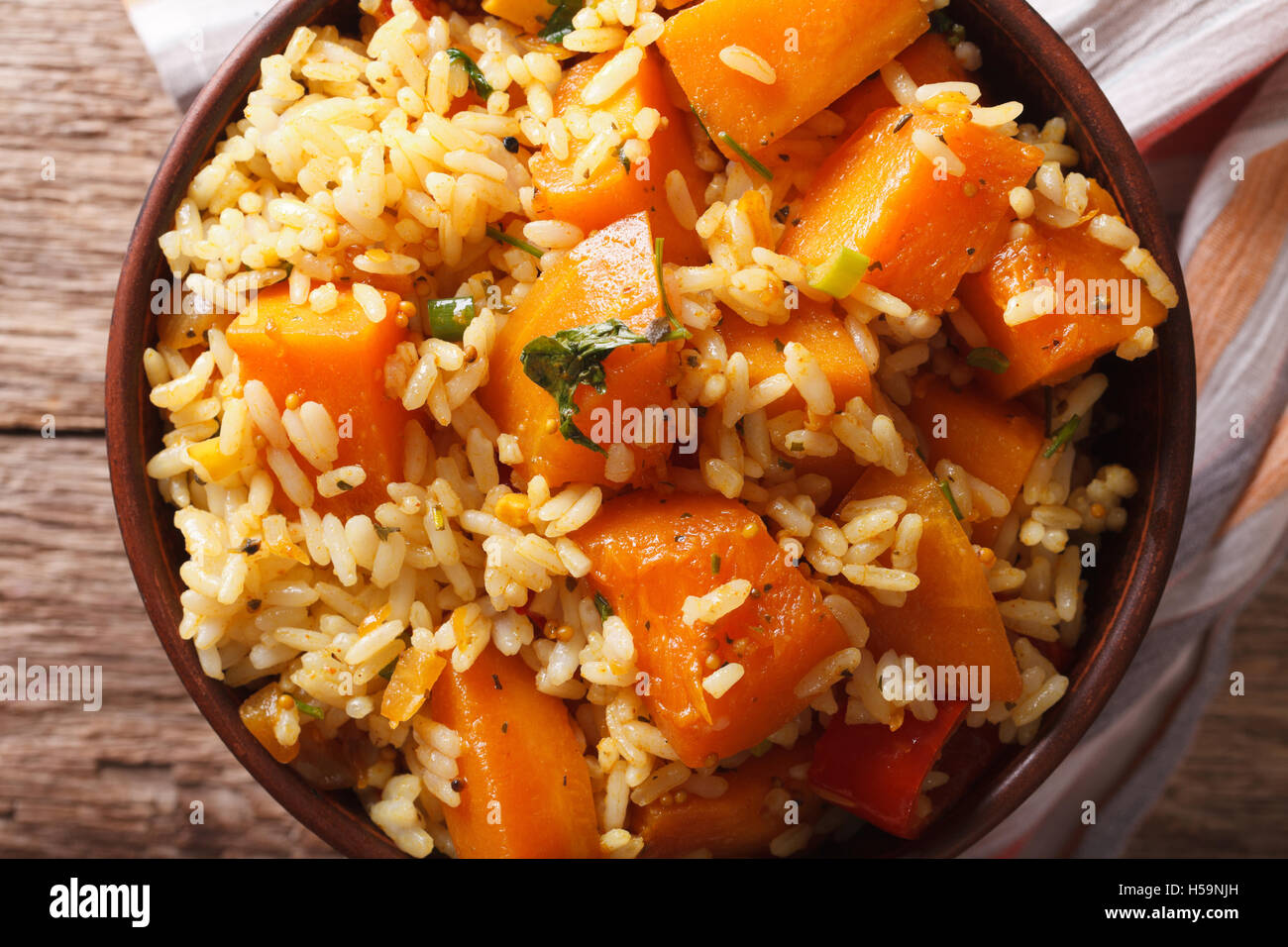 Cibo vegetariano: riso con la zucca in una ciotola vicino sul tavolo. Vista orizzontale dal di sopra Foto Stock