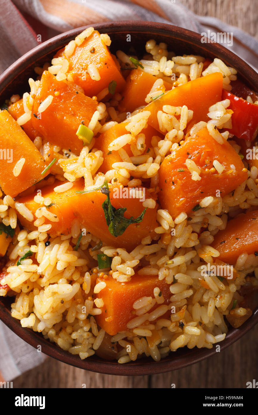 Cibo vegetariano: riso con la zucca in una ciotola vicino sul tavolo. vista verticale da sopra Foto Stock
