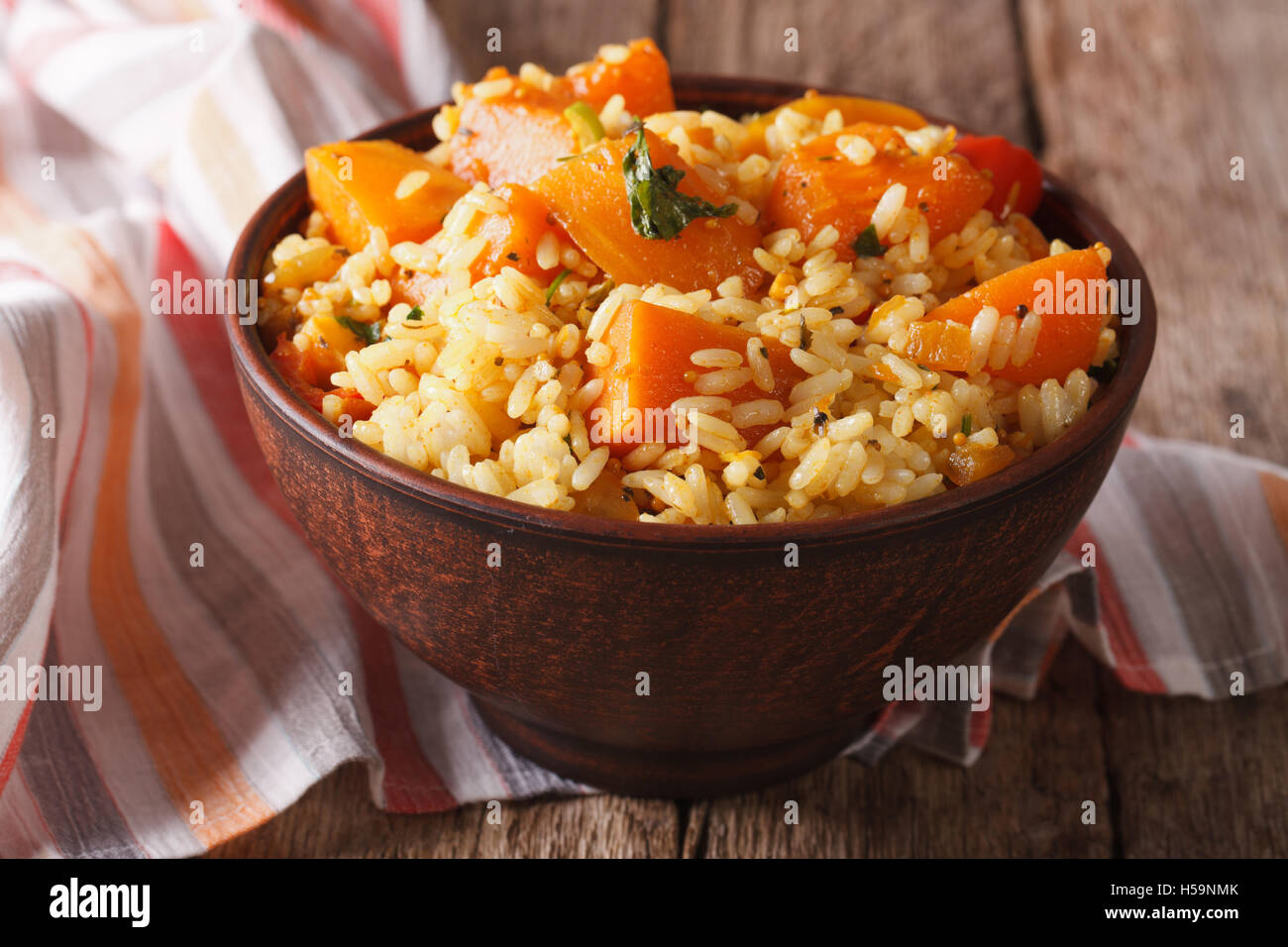 Cibo vegetariano: riso con la zucca in una ciotola sul tavolo. Posizione orizzontale Foto Stock