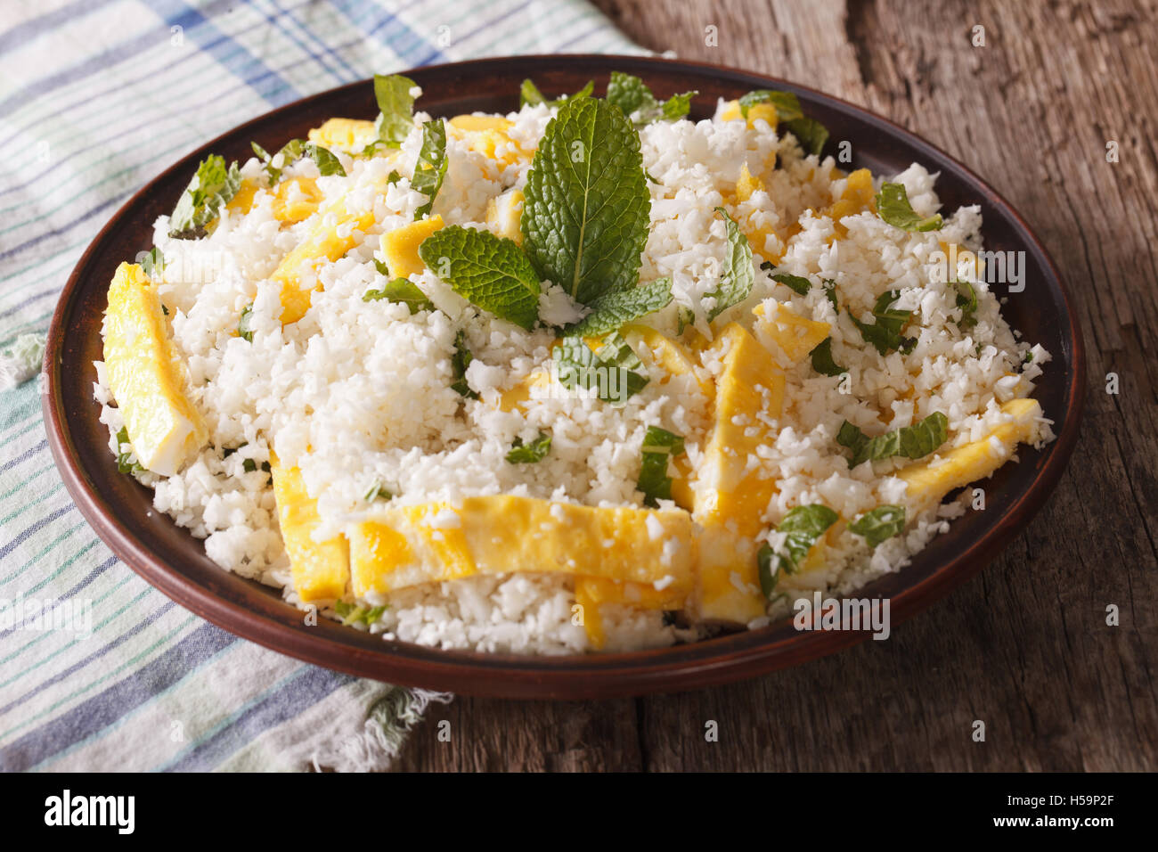 Il cavolfiore riso con uova e menta per paleo vicino sul tavolo orizzontale. Foto Stock