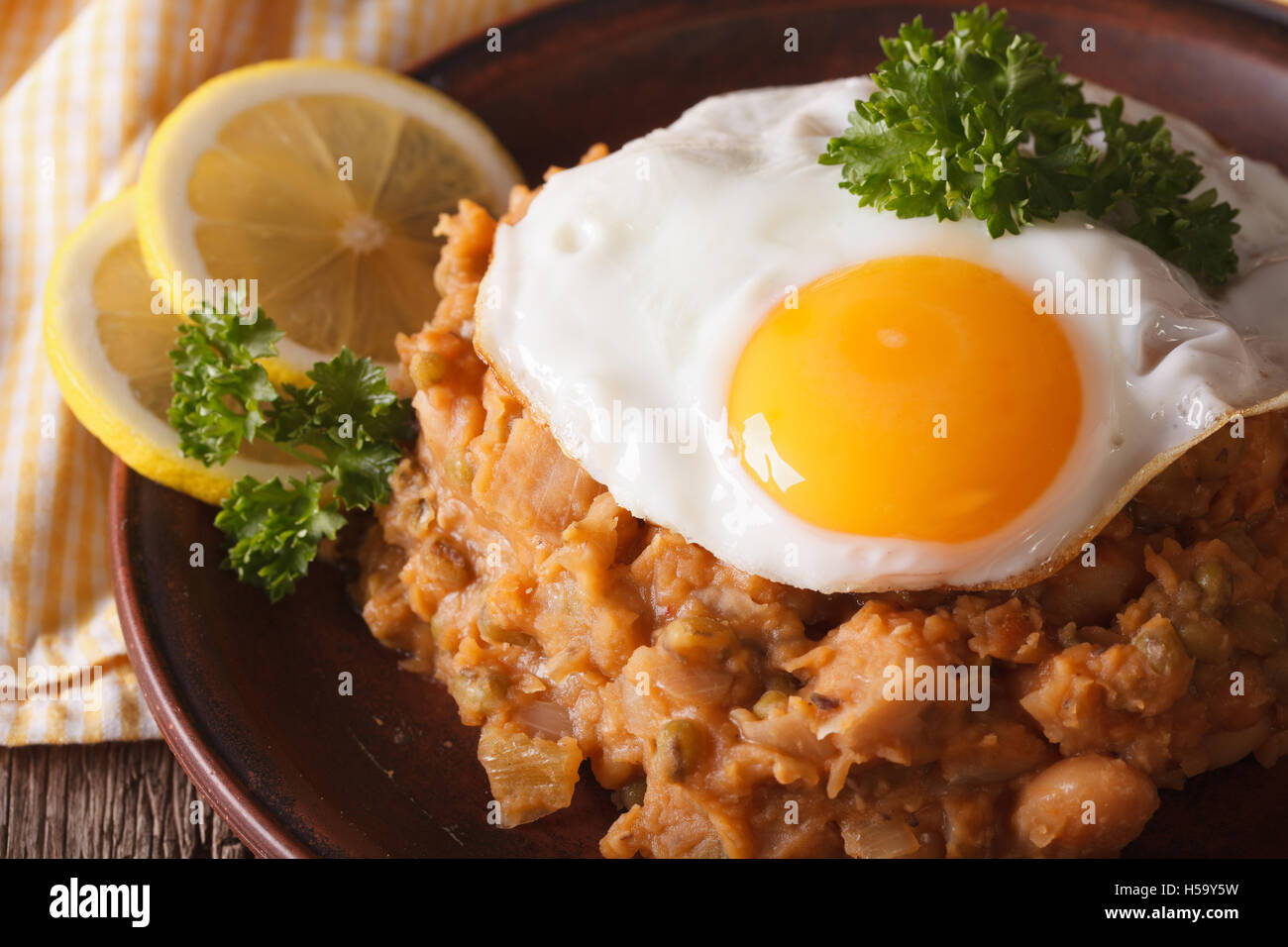 Cucina Araba: ful medames con un uovo fritto su una piastra macro. Posizione orizzontale Foto Stock