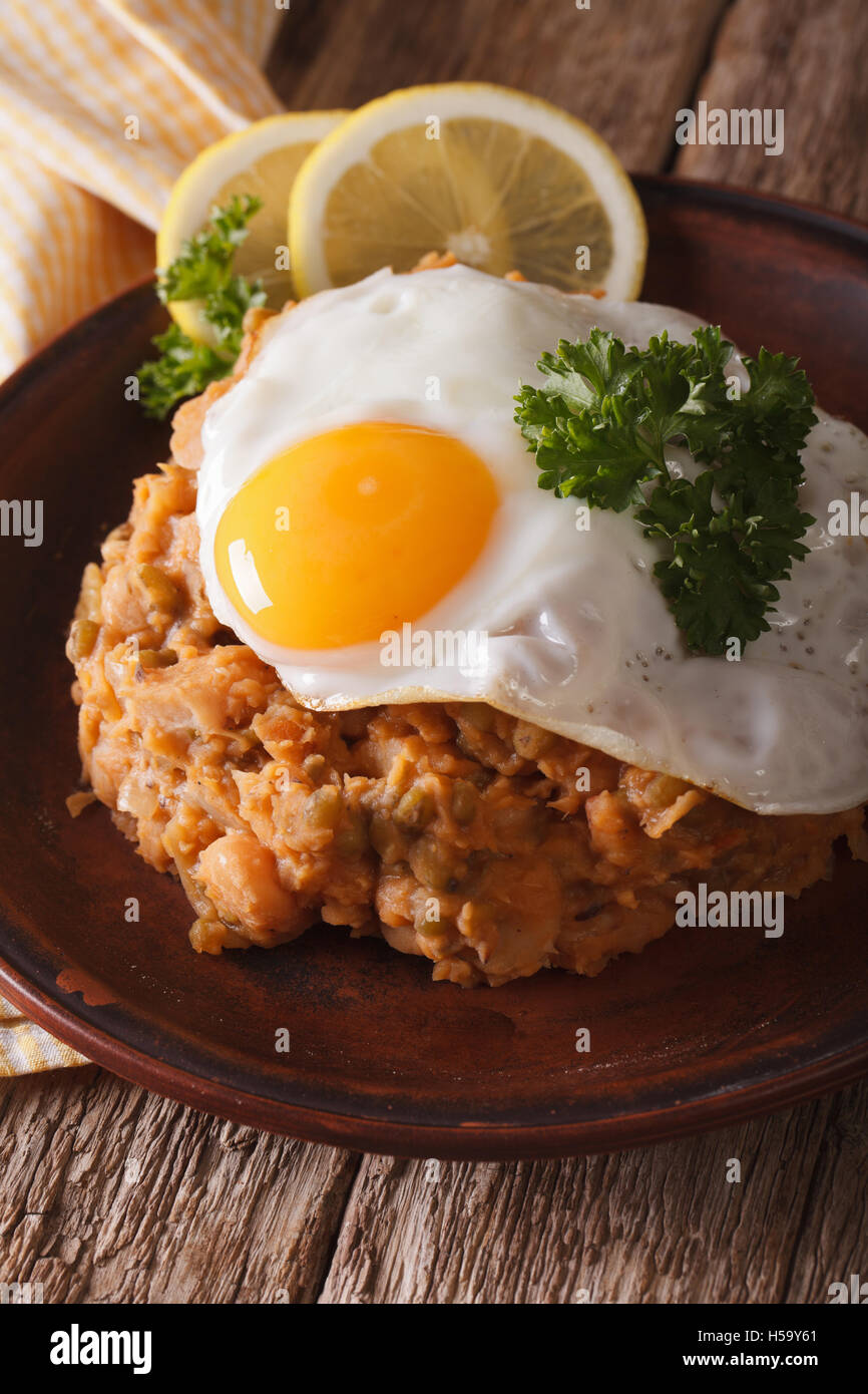 Cucina Araba: ful medames con un uovo fritto su una piastra di close-up verticale. Foto Stock