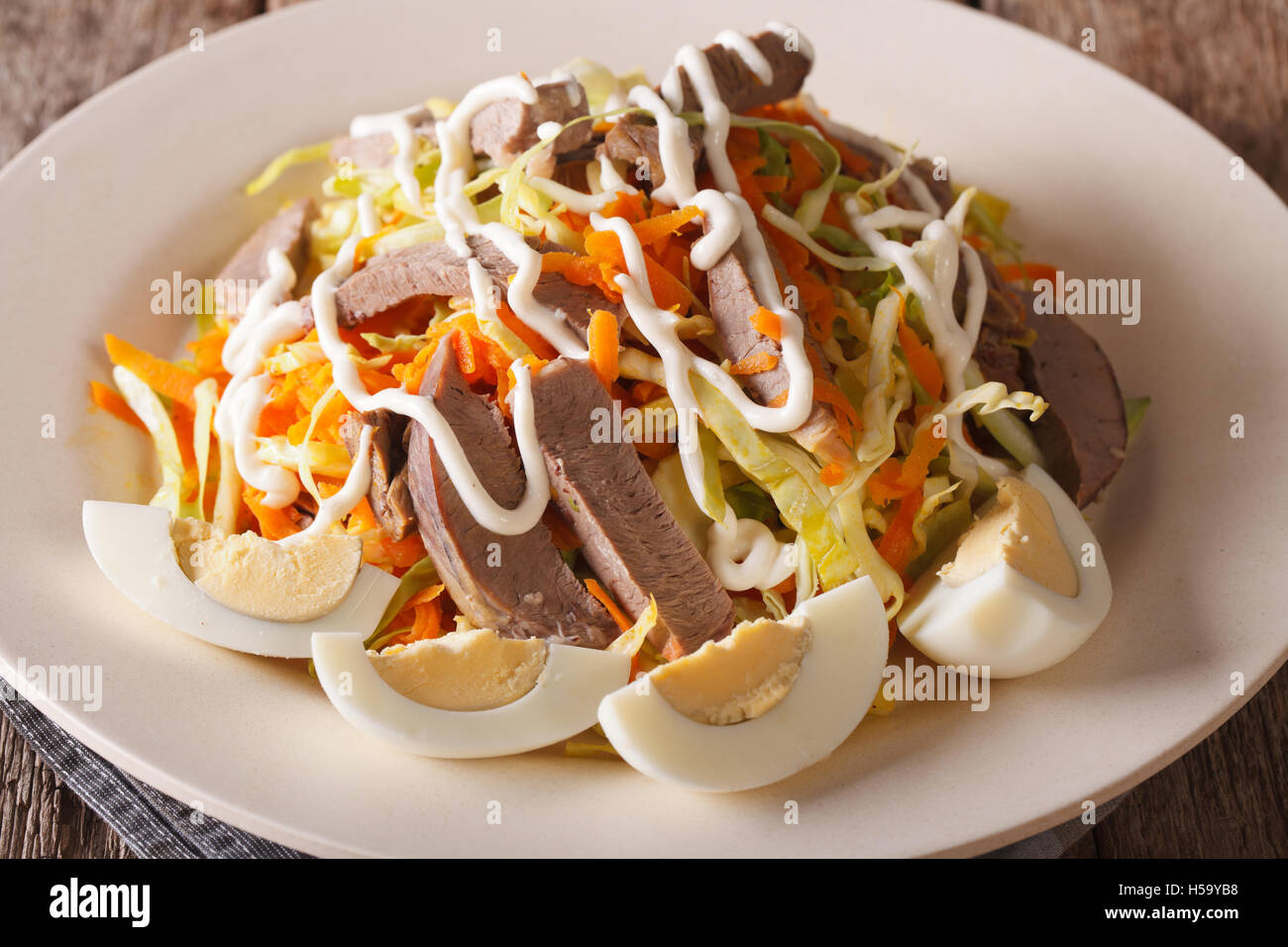 Insalata dal cuore di carne e verdura conditi con maionese vicino sul tavolo orizzontale. Foto Stock