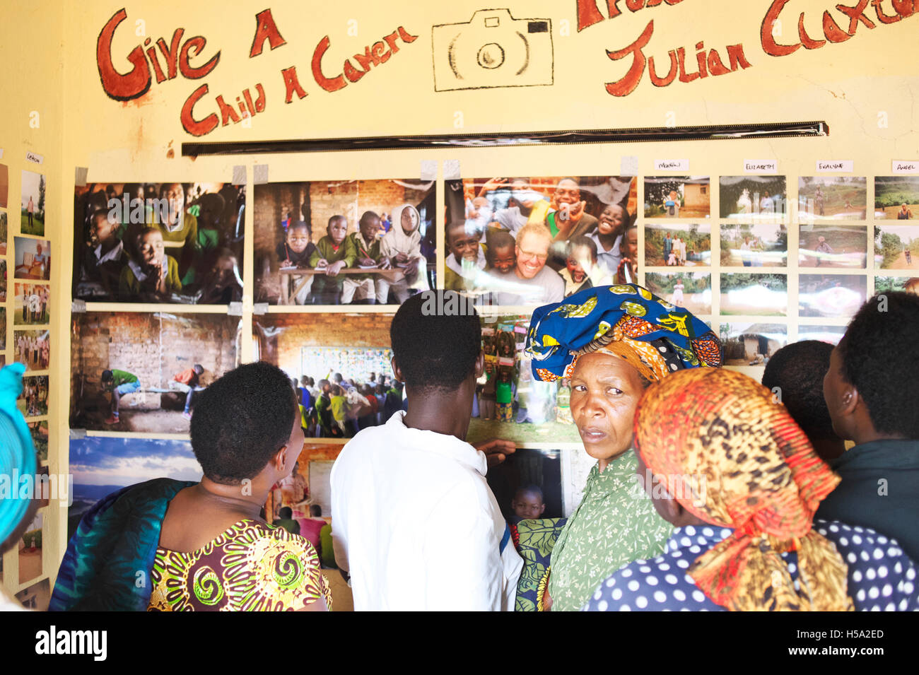 La scuola si apre durante la mostra nelle zone rurali in Uganda dove la comunità locale assiste per visualizzare le foto Foto Stock