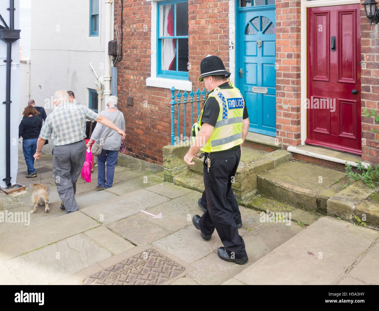 Poliziotto maschio e femmina il supporto di polizia funzionario comunitario in village street in Inghilterra. Regno Unito Foto Stock