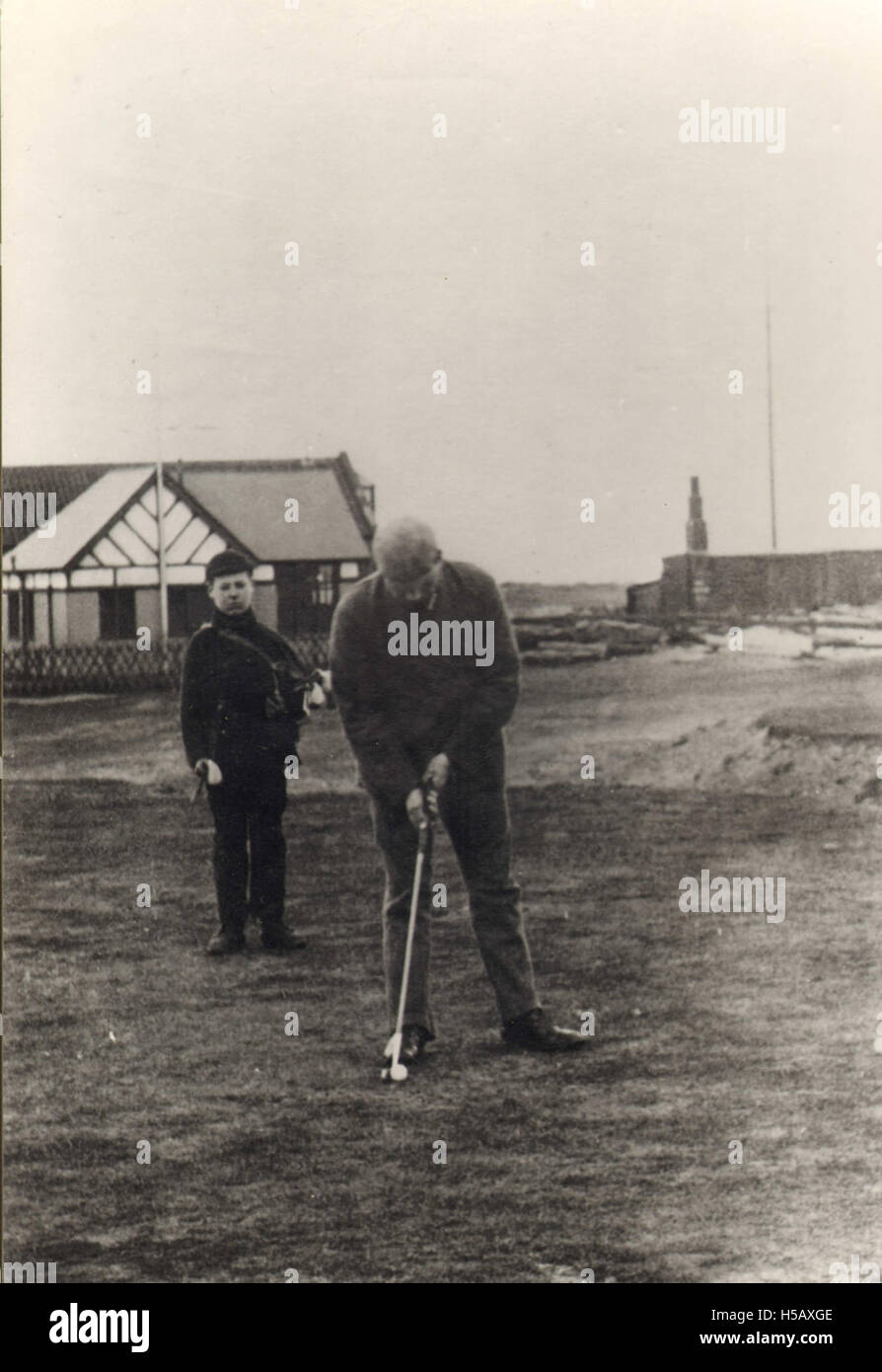 Questa immagine raffigura un golfista con il suo caddy, una partnership chiave nello sport del golf. Il caddy assiste il golfista nella selezione del club e offre consigli durante la partita, un ruolo essenziale nel golf professionale. Foto Stock