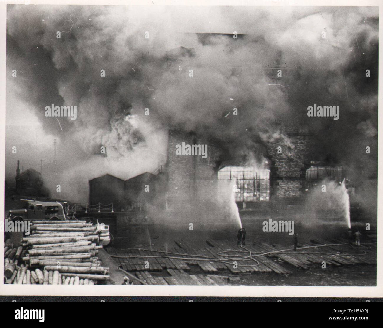 L'immagine intitolata "2 fumo e fiamme" si riferisce probabilmente all'incendio della fabbrica del 1954, un disastro industriale in cui incendi e fumo hanno causato danni significativi alla fabbrica e all'area circostante. Mette in evidenza i pericoli degli ambienti industriali durante quel periodo. Foto Stock