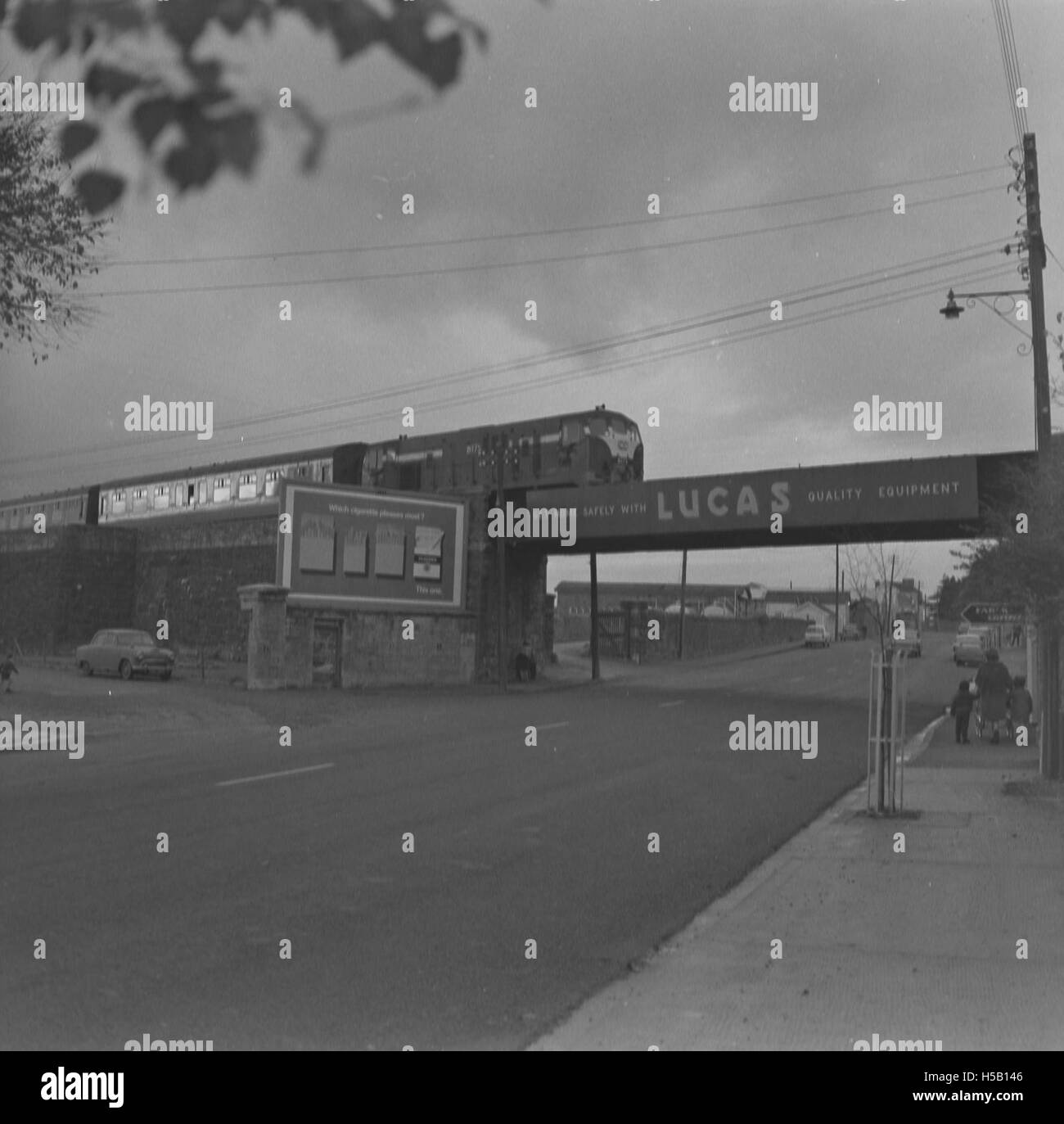 Questa immagine mostra probabilmente un treno che attraversa una strada a Fermoy, Contea di Cork, Irlanda. La scena può rappresentare la vita quotidiana o il trasporto all'inizio del XX secolo. Foto Stock