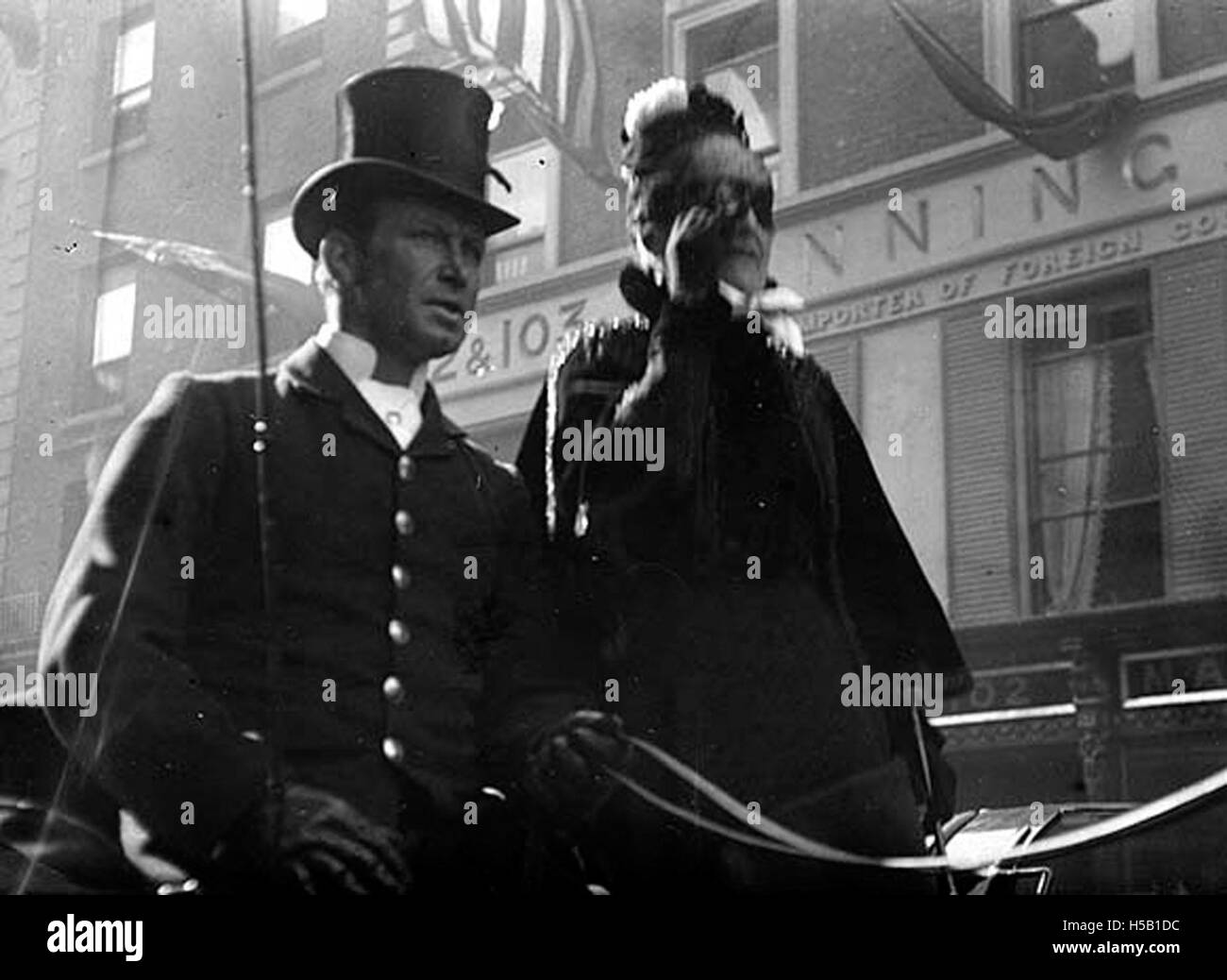 Una fotografia di un uomo e di una donna che passano al 102-103 di Grafton Street, che probabilmente mostra un momento della vita quotidiana in questa strada, catturato in un ambiente urbano. Foto Stock